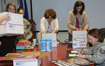 Air Force Operational Test and Evaluation Center members fill care packages for deployed members. (Center left) Anita Eichhorn, wife of AFOTEC Commander Maj. Gen. David Eichhorn, and (center right) Denise Eck, wife of AFOTEC Vice Commander Col. James Eck, help put packages together.
