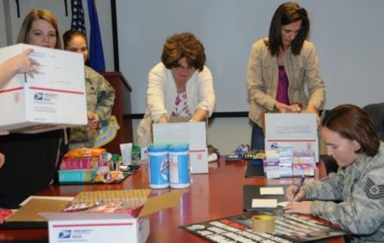 Air Force Operational Test and Evaluation Center members fill care packages for deployed members. (Center left) Anita Eichhorn, wife of AFOTEC Commander Maj. Gen. David Eichhorn, and (center right) Denise Eck, wife of AFOTEC Vice Commander Col. James Eck, help put packages together.