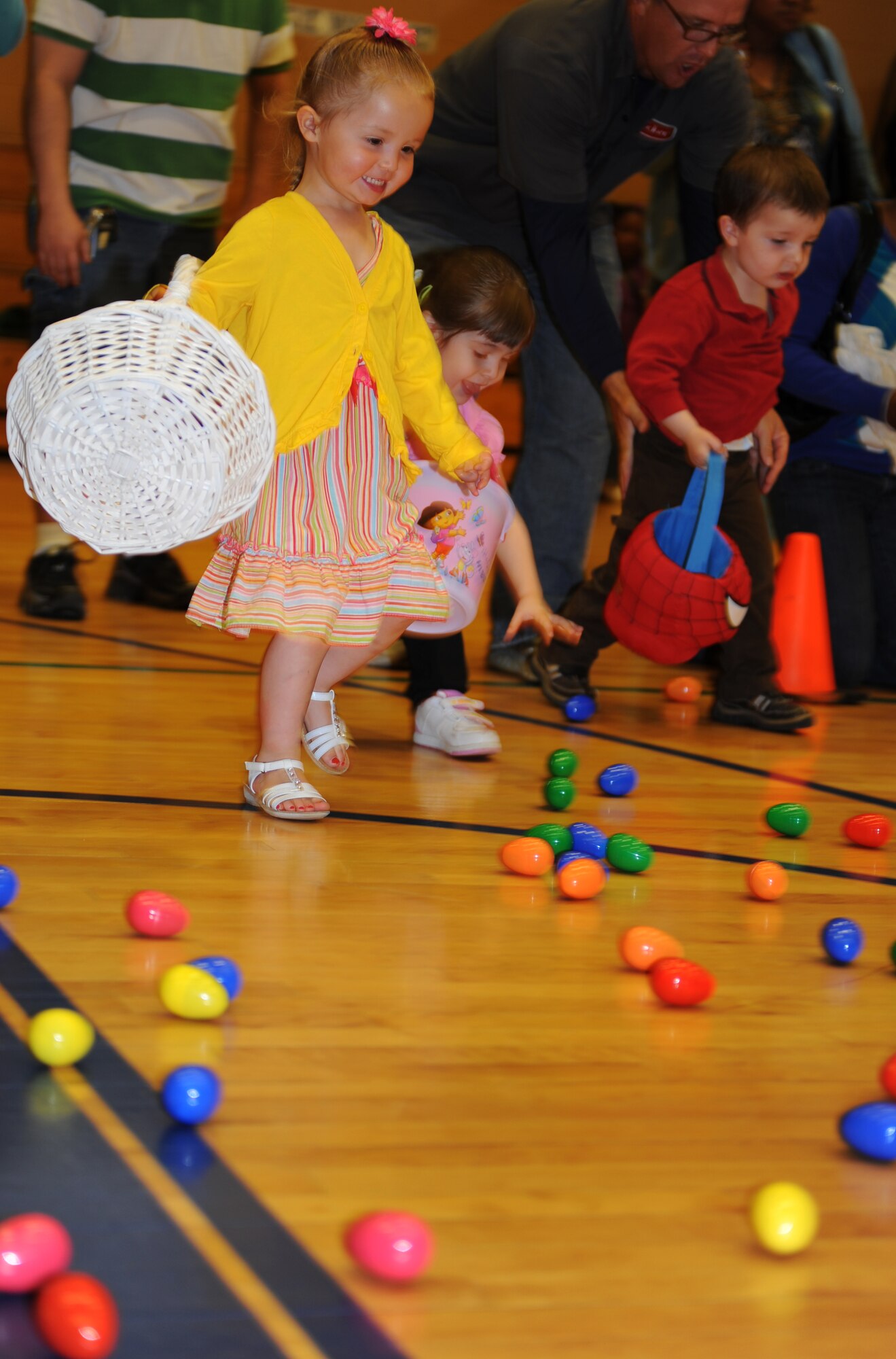 Bailey Comer, two year old daughter of Staff Sgt Sari Comer, 633d Comptroller Squadron, races to grab candy filled Easter eggs during the Month of the Military Child Extravaganza at Langley Air Force Base, Va., April 16, 2011. Children planted flowers, did science projects, and enjoyed Easter egg hunts at Bethel Manor Youth Center. (U.S. Air Force photo/Airman 1st Class Teresa Zimmerman/Released)