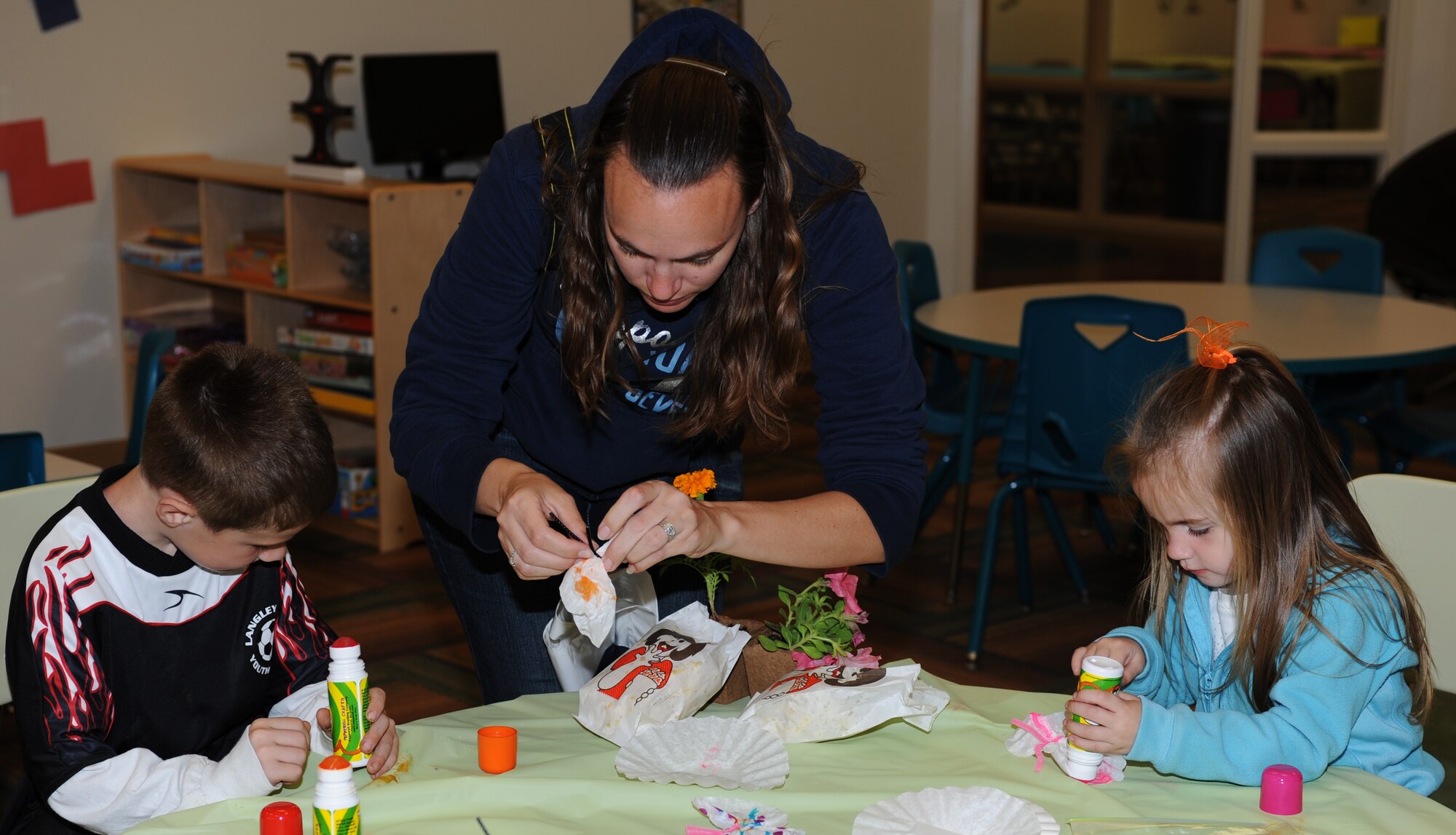 Sarah Fugate makes paper butterflies with son Michael, 6, and daughter Kylie, 3, during the Month of the Military Child Extravaganza at Langley Air Force Base, Va., April 16, 2011. Children planted flowers, did science projects, and enjoyed Easter egg hunts at the Bethel Manor Youth Center. (U.S. Air Force photo/Airman 1st Class Teresa Zimmerman/Released)
