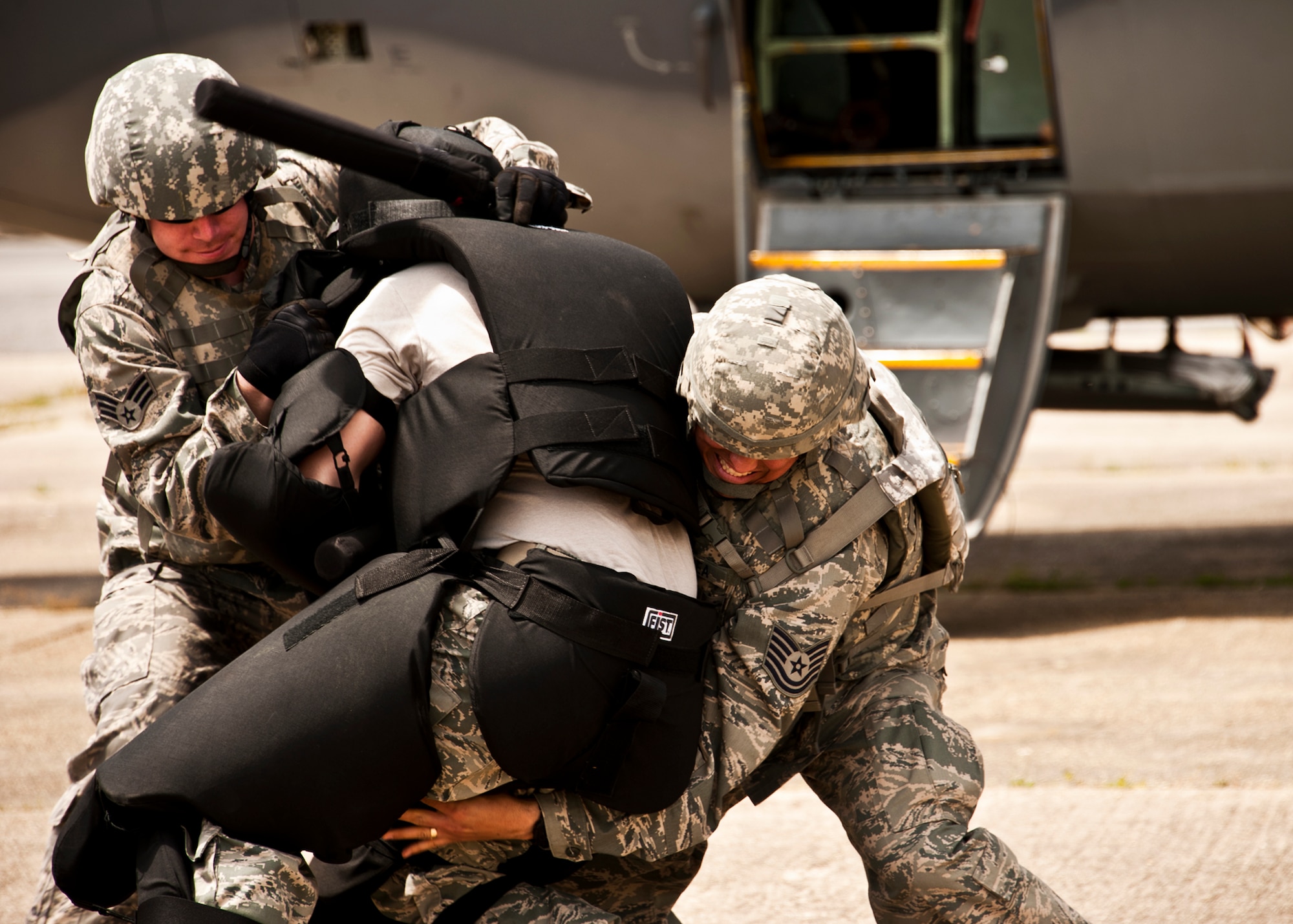 Senior Airman Cody Hoffman, 375th Security Forces Squadron, and Tech. Sgt. Jaime Correa, 17th Security Forces Squadron, take down a “simulated” enemy during a Fly Away Security Team training session April 14 at Eglin Air Force Base.  The course, taught by 96th Ground Combat Training Squadron instructors, brought together security forces Airmen from all over the U.S. to learn how to protect aircraft and handle a potential hostile situation.  (US. Air Force photo/Samuel King Jr.)