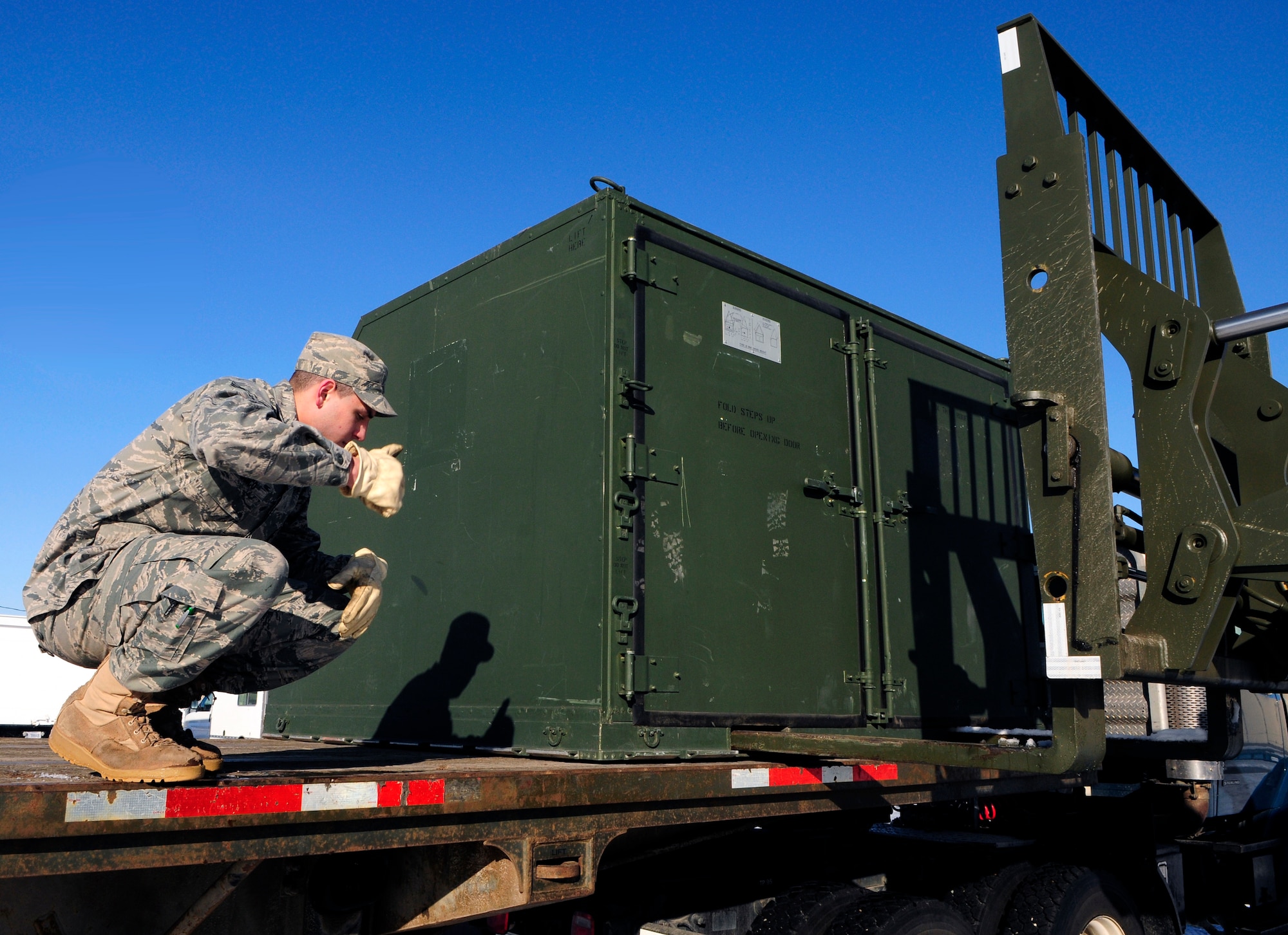 Airman 1st Class Richard Manco monitors the downloading of a storage container April 11, 2011, Eielson Air Force Base, Alaska.  As vehicle operators, Airmen are trained to use proper hand signals in the safe loading and unloading of Air Force cargo.  Airman Manco is assigned to the 354th Logistics Readiness Squadron distribution flight as a vehicle operator and dispatcher.  (U.S. Air Force photo/Airman 1st Class Yash Rojas)