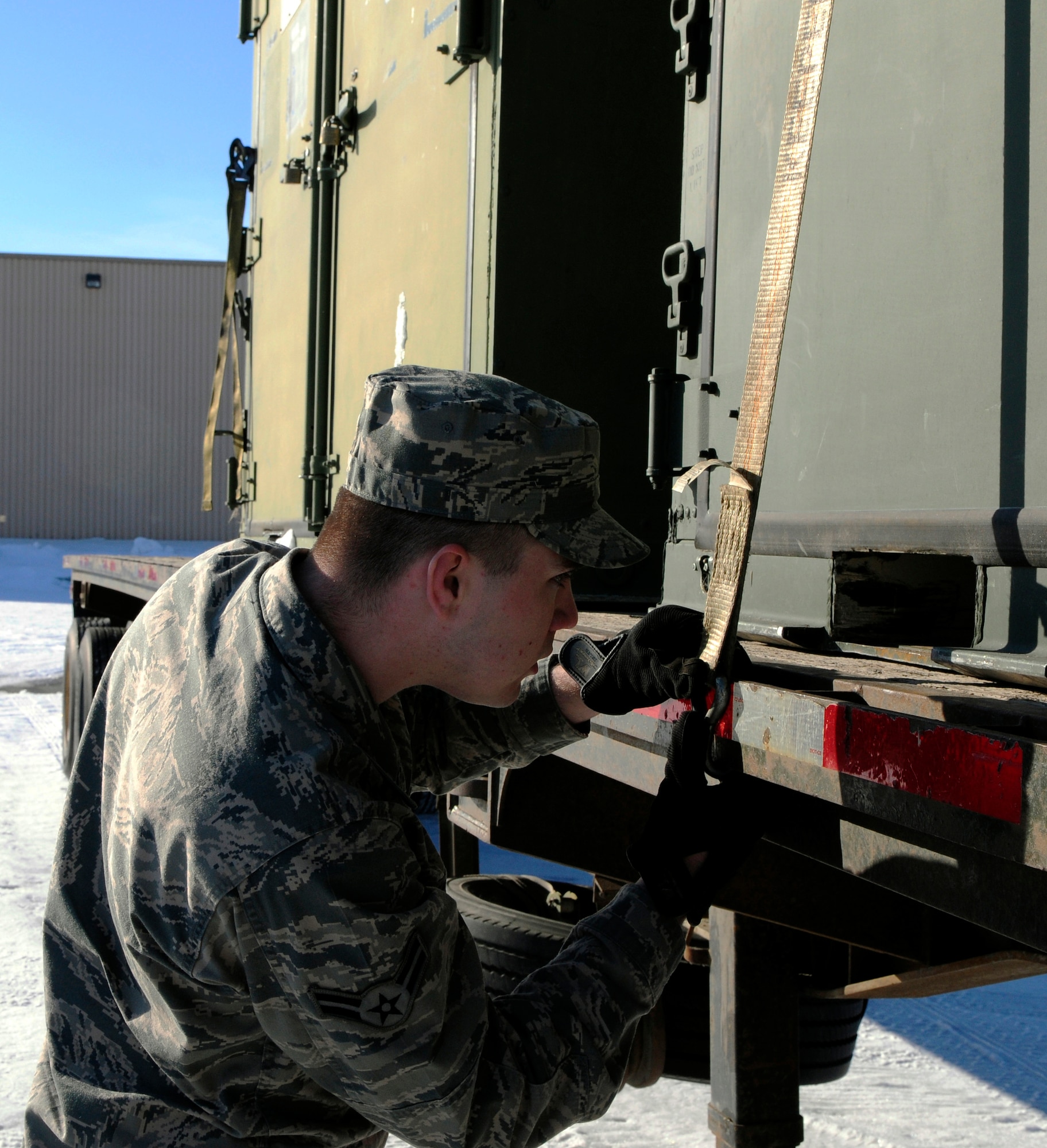 Airman 1st Class Michael Durgin straps storage containers down safely with ratcheting tie-down straps April 11, 2011, Eielson Air Force Base, Alaska.  The vehicle operations section responsibilities include the safe transportation of people, cargo and equipment.  Airman Durgin is assigned to the 354th Logistics Readiness Squadron distribution flight as a vehicle operator and dispatcher.  (U.S. Air Force photo /Airman 1st Class Yash Rojas)