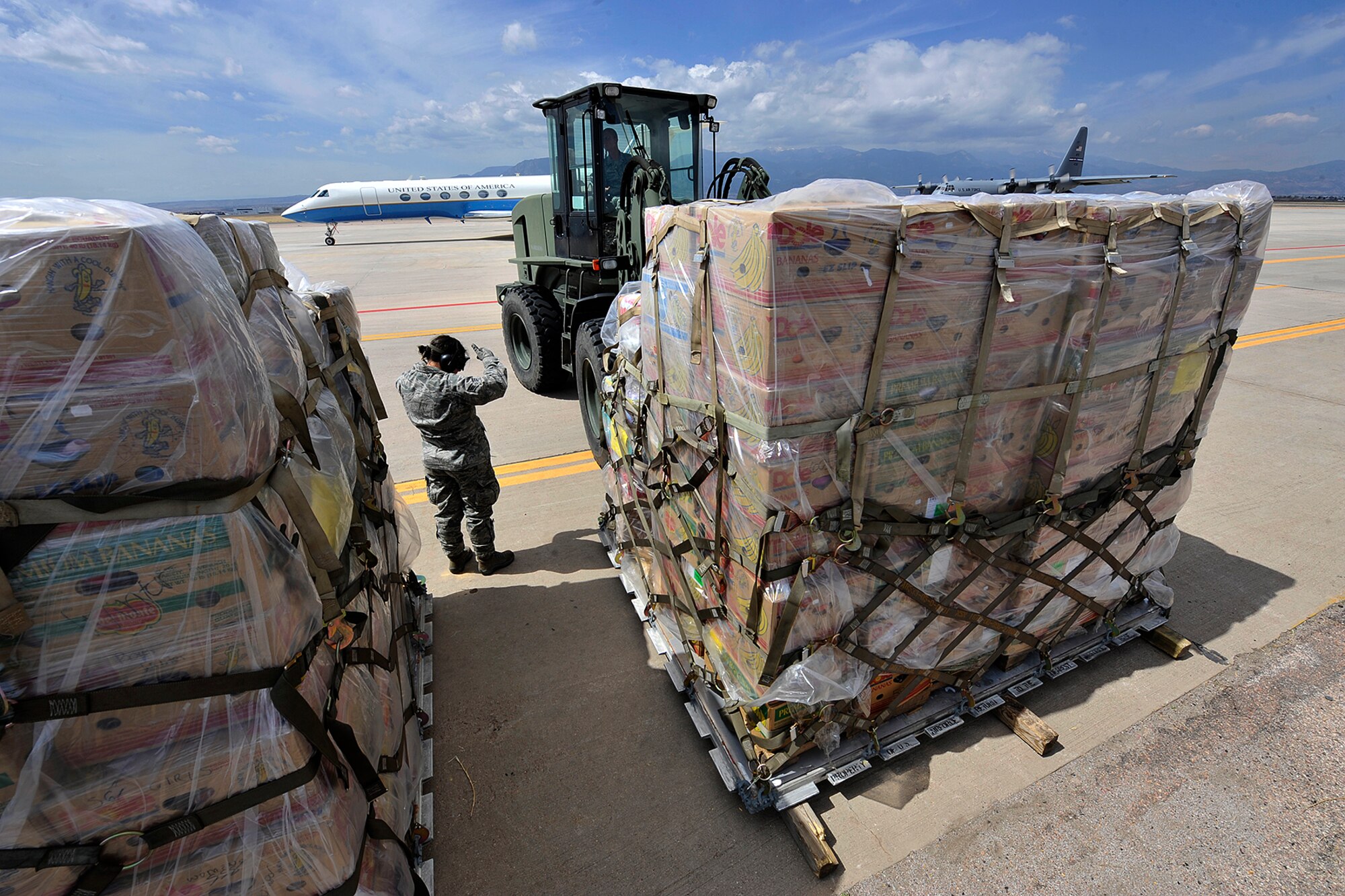 PETERSON AIR FORCE BASE, Colo. – Senior Airman Amy Weldy, 39th Aerial Port Squadron, guides a forklift unloading humanitarian assistance cargo April 13, 2011, on the Peterson Air Force Base flightline. About 40,000 pounds of relief aid, mostly coats and cold weather apparel, was donated by charitable organizations in Loveland, Colo. The pallets were unloaded by 21st Logistics Readiness Squadron and 39th APW Airmen as an engine running offload operation, typically used for tactical operations where time and ramp space are of critical importance, providing vital training for the Airmen. The pallets will be loaded onto a KC-10 and sent to Charleston AFB, S.C., before making their way to Afghanistan. (U.S. Air Force photo/Rob Bussard)