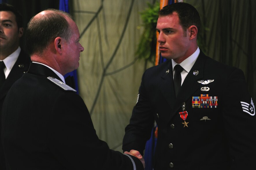 Staff Sgt. Mark McHan, 38th Rescue Squadron pararescueman, receives the Bronze Star Medal with Valor from Brig. Gen.  Eugene Haase, Headquarters Special Operations Command director of force structure, requirements, resources and strategic assessments, during the Rescue Ball at Moody Air Force Base, Ga., April 15. Sergeant McHan received this medal for his heroic actions while performing an urgent medical evacuation when his team came under enemy fire during a deployment to Afghanistan on July 29, 2009. Sergeant McHan placed himself between enemy fire and patients as they were loaded onto an HH-60G Pave Hawk. (U.S. Air Force photo/Airman 1st Class Benjamin Wiseman)(RELEASED)