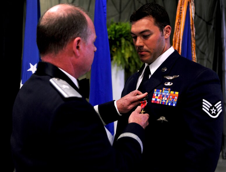 Staff Sgt. Mark Bedell, 38th Rescue Squadron pararescueman, receives the Bronze Star Medal with Valor from Brig. Gen.  Eugene Haase, Headquarters Special Operations Command director of force structure, requirements, resources and strategic assessments, during the Rescue Ball at Moody Air Force Base, Ga., April 15. Sergeant Bedell received this medal for his heroic actions while performing an urgent medical evacuation when his team came under enemy fire during a deployment to Afghanistan on July 29, 2009. Sergeant Bedell volunteered to stay on the ground and aid his team by holding their position as patients and other team members were evacuated. (U.S. Air Force photo/Airman 1st Class Benjamin Wiseman)(RELEASED)
