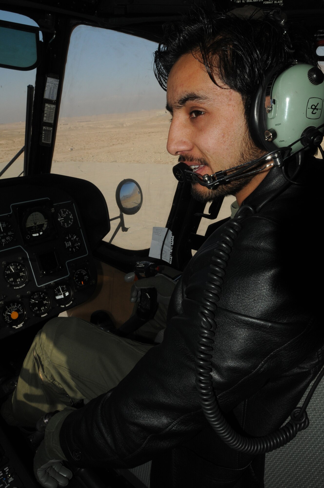Afghan Air Force 1st Lt. Ahmad Fawad Haidari looks over to his instructor pilot during a training flight outside of Kabul. Haidari and 1st Lt. Abdul Saboor Amin, the first two Afghan helicopter pilots to go through basic aviator training in the U.S., recently became co-pilot qualified in the Mi-17. (U.S. Navy photo by Mass Communications Specialist 2nd Class Vladimir Potapenko)