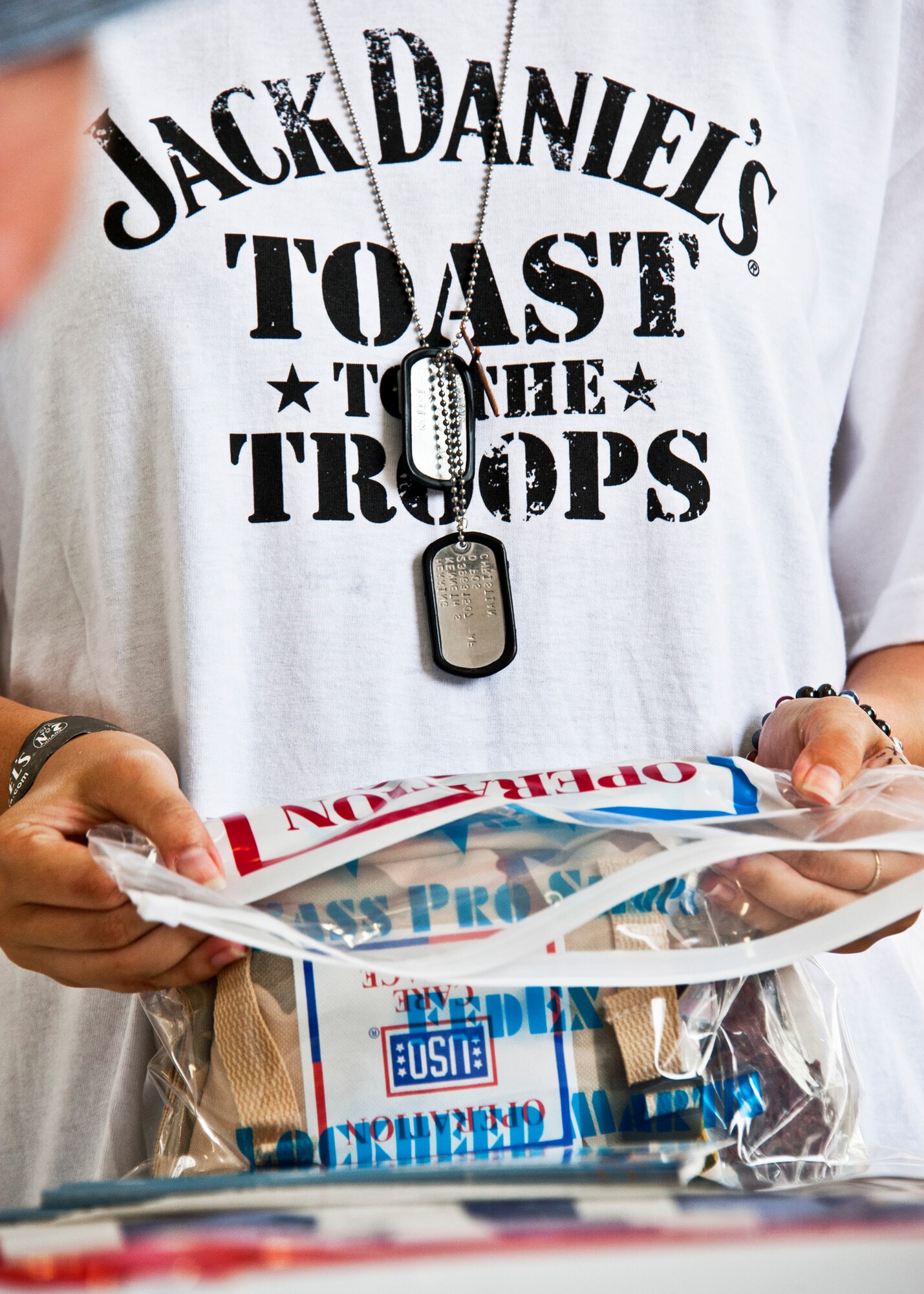 A volunteer secures a care package in a plastic bag as the final step in stuffing goodie bags. More than 180 volunteers participated in the Jack Daniel's/USO Toast to the Troops Program by assembling thousands of Operation USO Care Packages April 15. More than 150,000 care packages have been sent to troops through this program since 2005. (USAF photo/Samuel King Jr.)     

