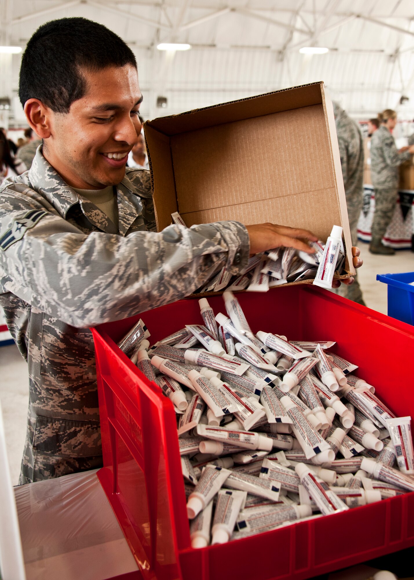 An Airman keeps the toothpaste flowing for the volunteers stuffing goodie bags for deployed personnel.  More than 180 volunteers participated in the Jack Daniel's/USO Toast to the Troops Program by assembling thousands of Operation USO Care Packages April 15. More than 150,000 care packages have been sent to troops through this program since 2005. (USAF photo/Samuel King Jr.)     

