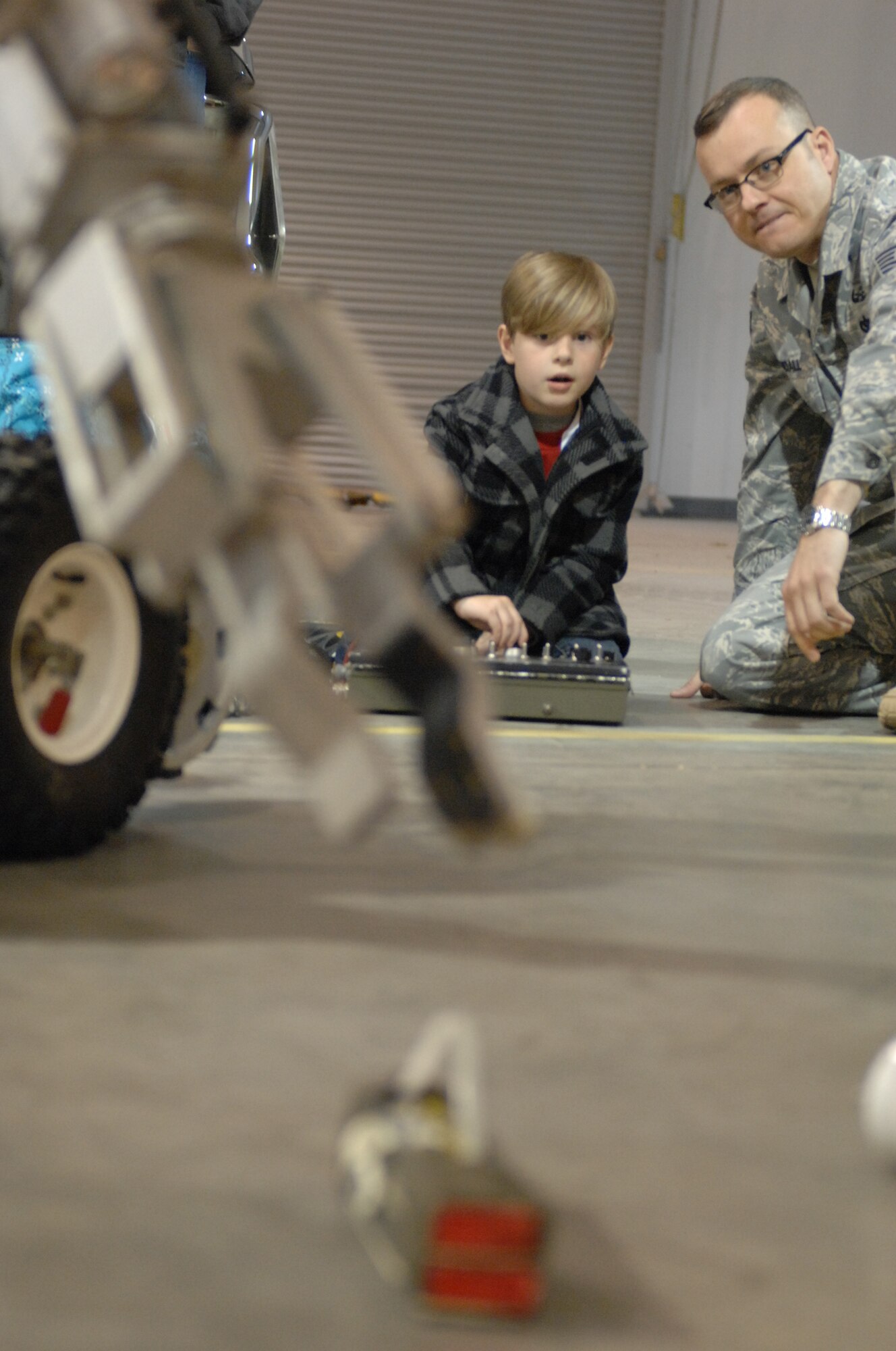 WHITEMAN AIR FORCE BASE, Mo. -- Tech. Sgt. Rob Randall, 509th Civil Engineer Squadron explosive ordnance disposal operator, shows a child how to operate a bomb removal robot during Operation Spirit April 16, 2011. Operation Spirit is hosted once a year to show military children a piece of what their parents might experience through a deployment.  (U.S. Air Force photo by Airman 1st Class Cody H. Ramirez)
