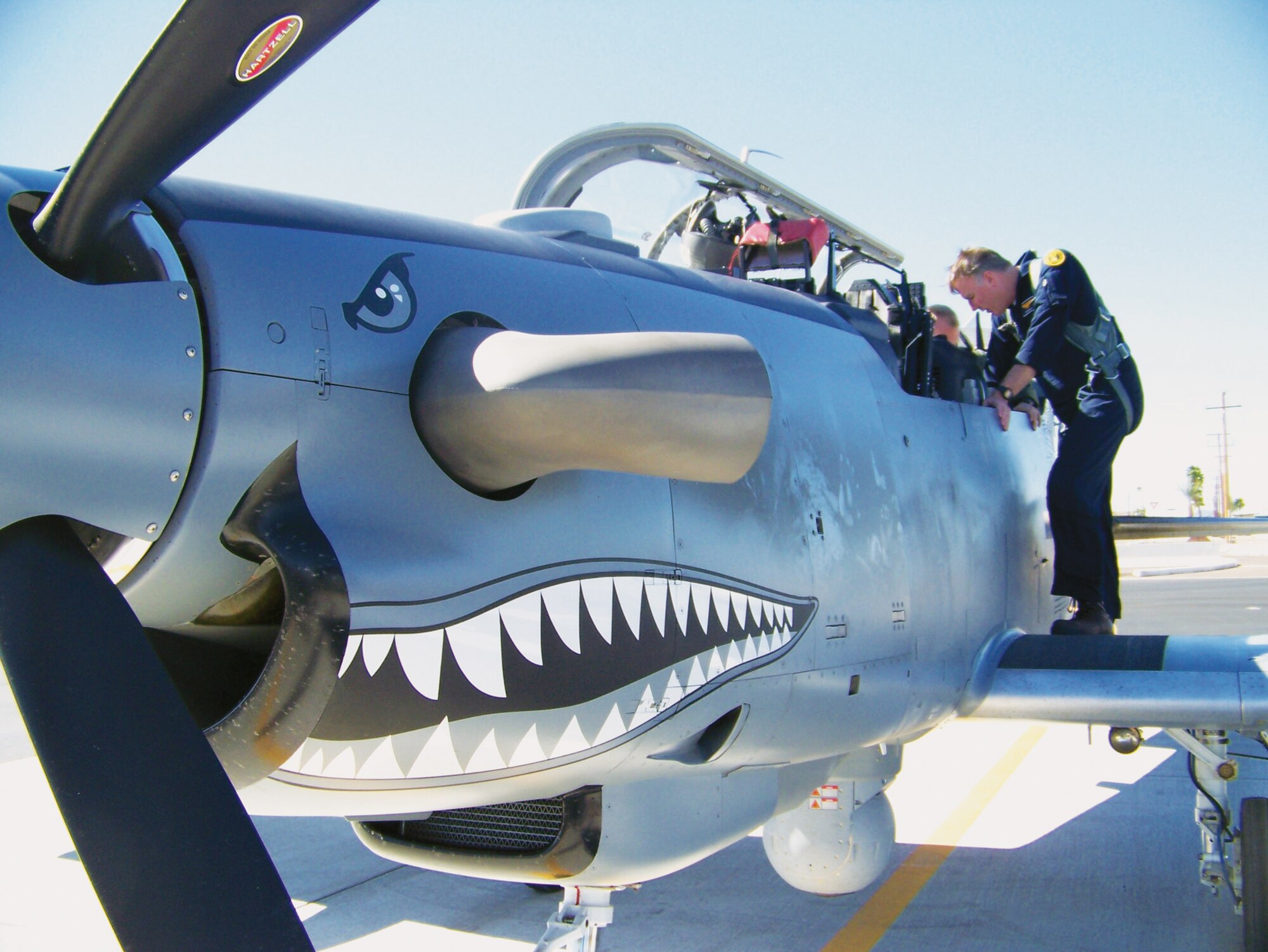 Dan Hinson, Hawker-Beechcraft Corporation AT-6C lead test pilot, talks with Maj. Evans Boeve, Air National Guard/Air Force Reserve Center Test Center sensor program manager, while he straps into the cockpit for a test flight in the AT-6.  The test team performed an operational assessment on the airplane's weapons integration systems on the Barry M. Goldwater Range.  (U.S. Air Force photo/Teresa Walker)