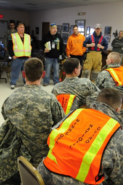 Oslo city officials (standing in background) and Minnesota Army National Guard soldiers discuss the details of the recent evacuation exercise in the city of Oslo on April 14, 2011. Civil authorities, civilians and soldiers jointly participated in the evacuation exercise to better prepare for a real evacuation scenario.  (U.S. Air Force photo by Tech. Sgt. Brett R. Ewald)