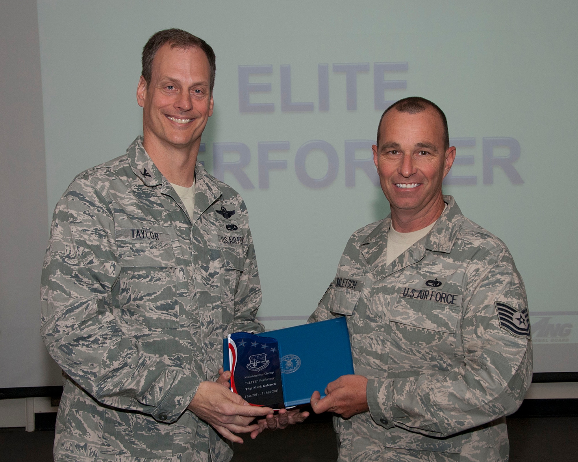 Col. James Taylor (left) presents Tech. Sgt. Mark Kaletsch the Elite Performer Award for his work with the 148th Fighter Squadron. (U.S. Air Force photo/Master Sgt. David Neve)