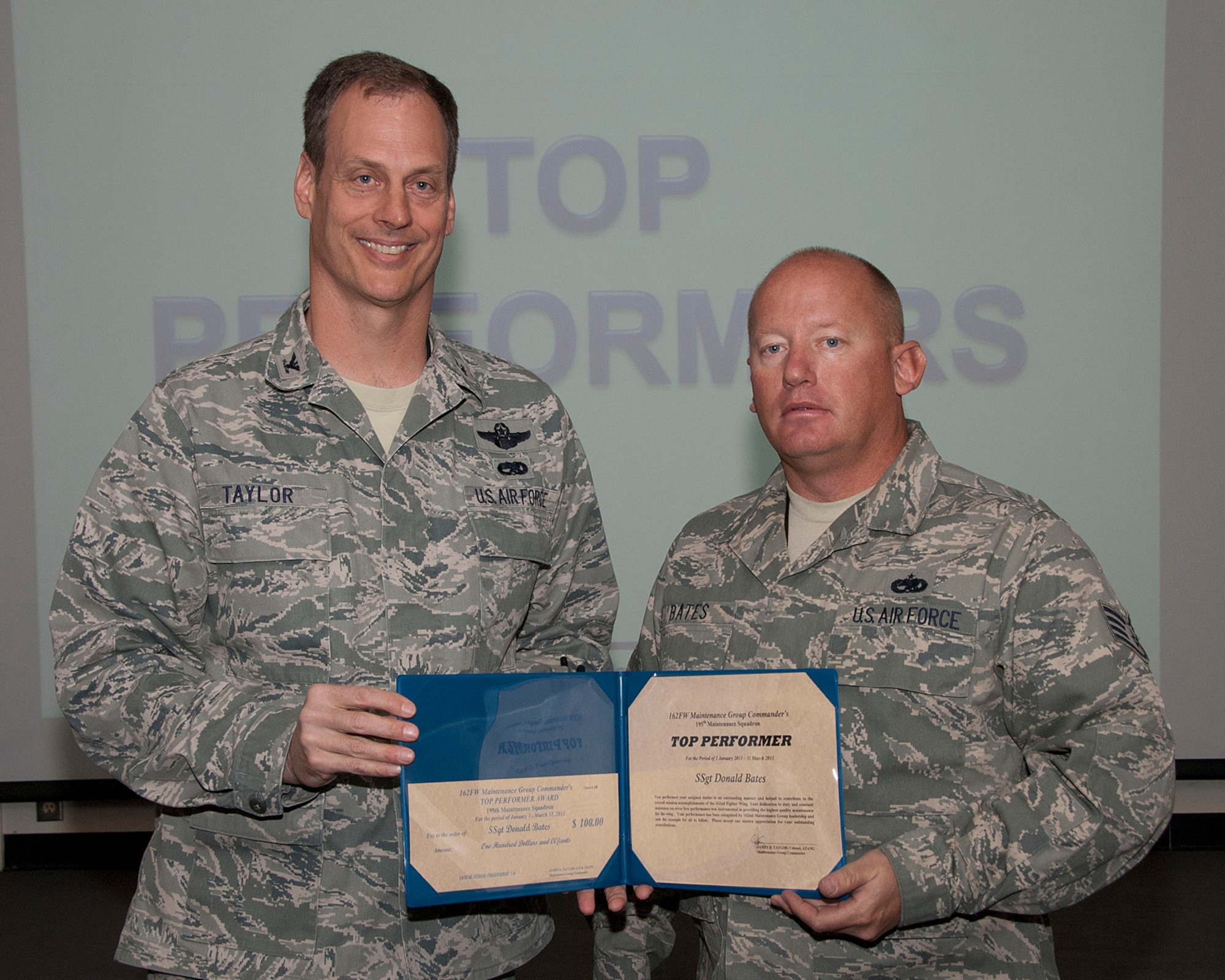 Col. James Taylor (left) presents Staff. Sgt. Donald Bates the Top Performers Award for his work with the 195th Fighter Squadron.  (U.S. Air Force photo/Master Sgt. David Neve)