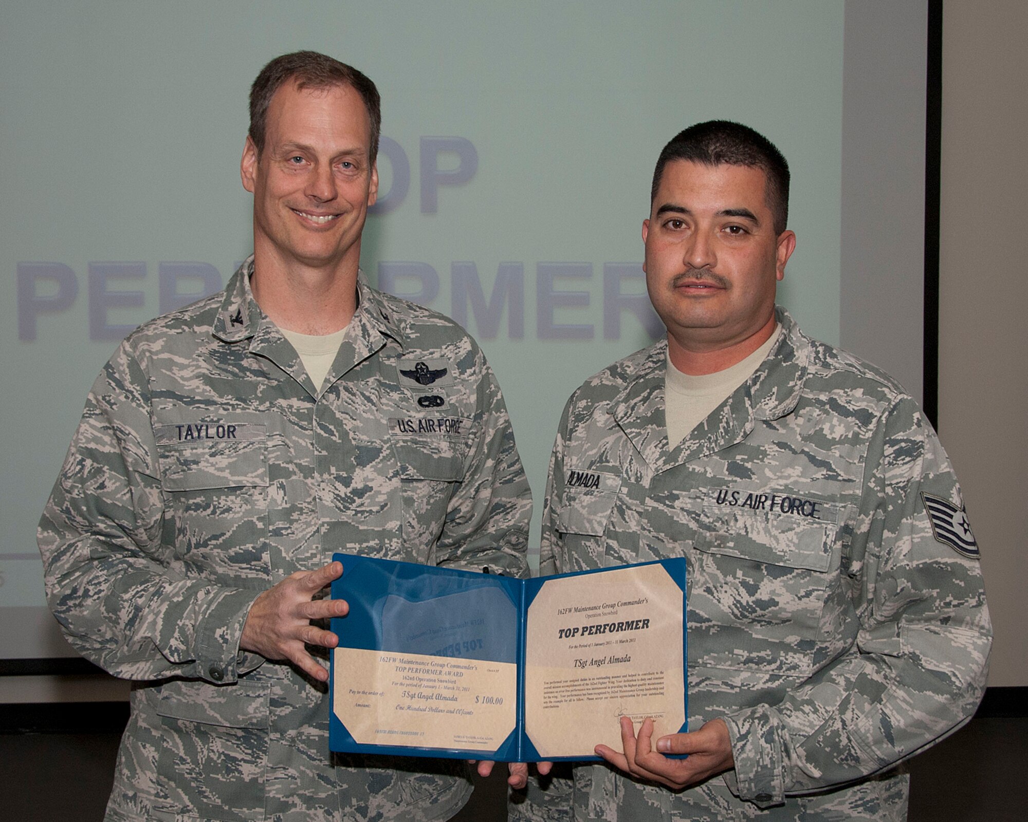 Col. James Taylor (left) presents Tech. Sgt. Angel Almada the Top Performers Award for his work with Operation Snowbird.  (U.S. Air Force photo/Master Sgt. David Neve)