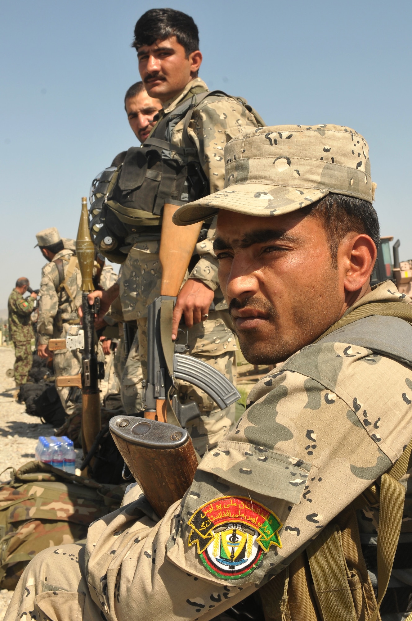 SHINDAND, Afghanistan – Afghan Border Police troops wait on the helipad to be escorted from Jalalabad to Barge Matal in the Kunar Valley as part of a combat resupply mission conducted by the Afghan Air Force and NATO Air Training Command-Afghanistan. In an effort to contribute fresh troops and provisions to the village located near the Afghan/Pakistan border, the mission swapped out 40 members of the ABP and delivered over 9,000 kilograms of weapons, ammunition, food and medical supplies. (U.S. Navy photo by Mass Communications Specialist 2nd Class Vladimir Potapenko)