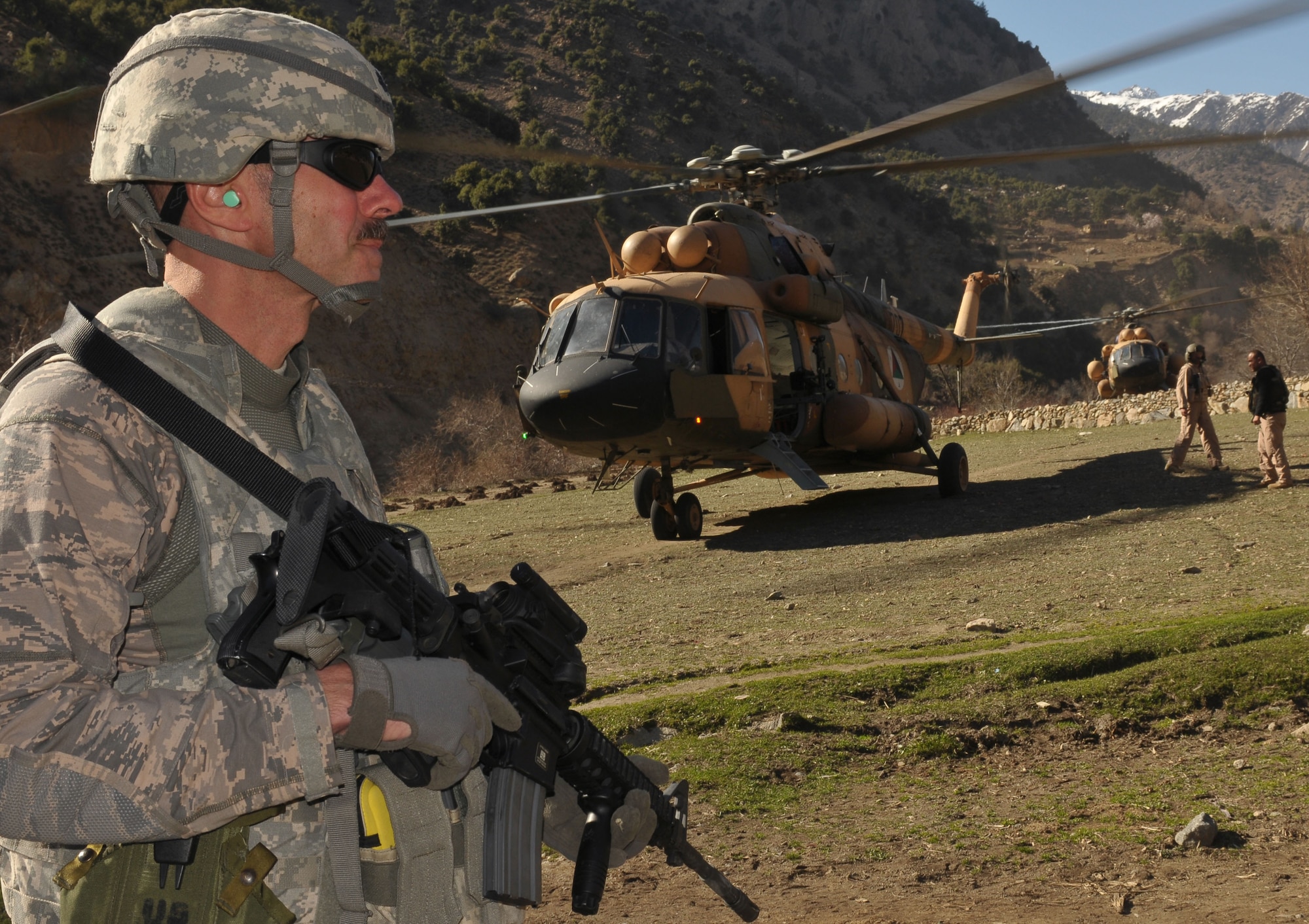 Lt. Col. Mark Reents, a NATO Air Training Command-Afghanistan advisor deployed to Kabul, provides security during a combat resupply mission to Barge Matal in the Kunar Valley conducted by the Afghan Air Force and NATO Air Training Command-Afghanistan, April 14, 2011. In an effort to contribute fresh troops and provisions to the village located near the Afghan/Pakistan border, the mission swapped out 40 members of the ABP and delivered over 9,000 kilograms of weapons, ammunition, food and medical supplies. (U.S. Navy photo by Mass Communications Specialist 2nd Class Vladimir Potapenko)