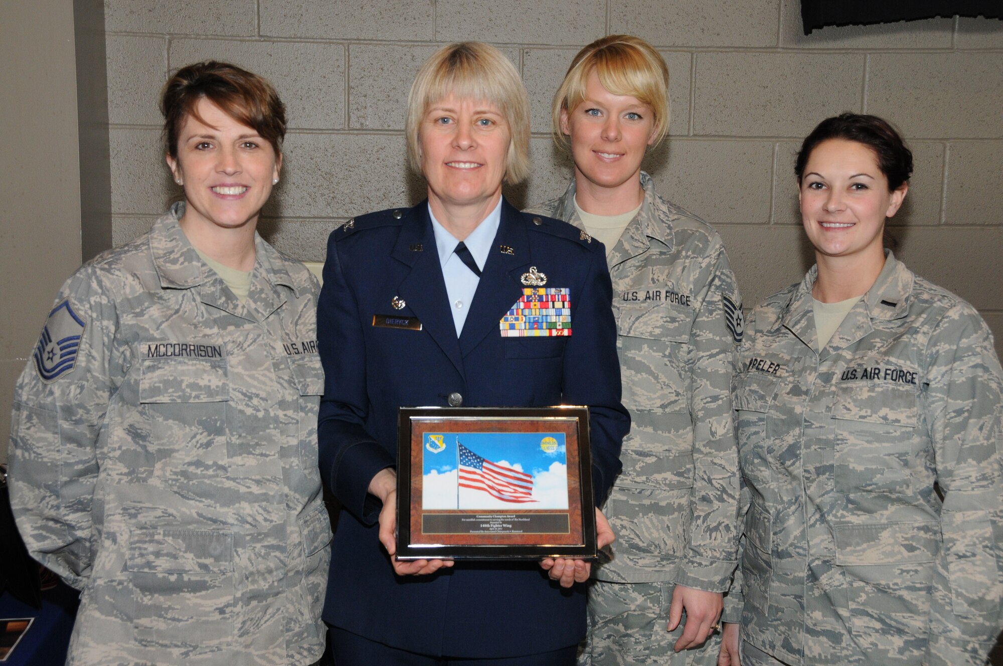 U.S. Air Force Col. Penny Dieryck, commander of the 148th Fighter Wing's Mission Support Group, poses with fellow airmen after accepting the Community Champion Award in Duluth, Minn., April 16, 2011. The Community Champion Award, presented by Dr. Anthony Macioce of Associated Chiropractic, was given to the 148 FW for continued unselfish commitment to serving the needs of the local community. (U.S. Air Force photo by Senior Airman Sarah C. Hayes)