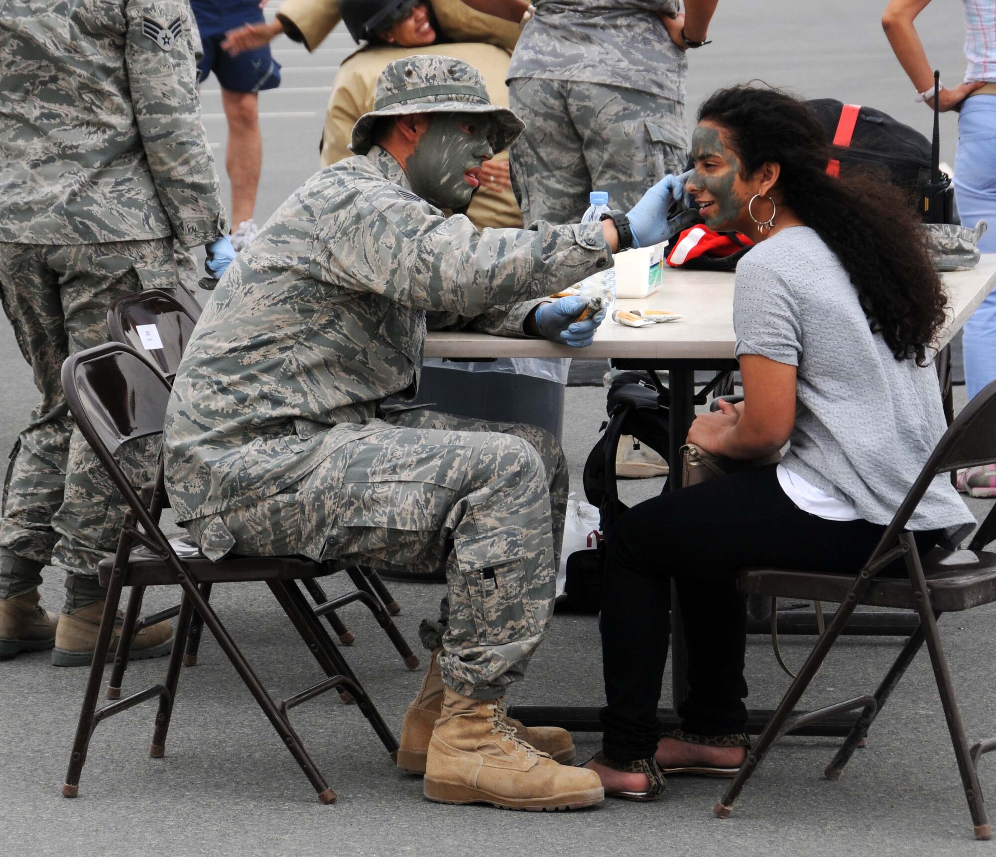 Staff Sgt Benjamin Roa, from the 379th Chapel puts face paint on a student from the American School April 14 in Southwest Asia.  Airmen from the 379th Air Expeditionary Wing spent the day with the students participating in different activities. (U.S. Air Force photo/ Staff Sgt. Anthony Graham)