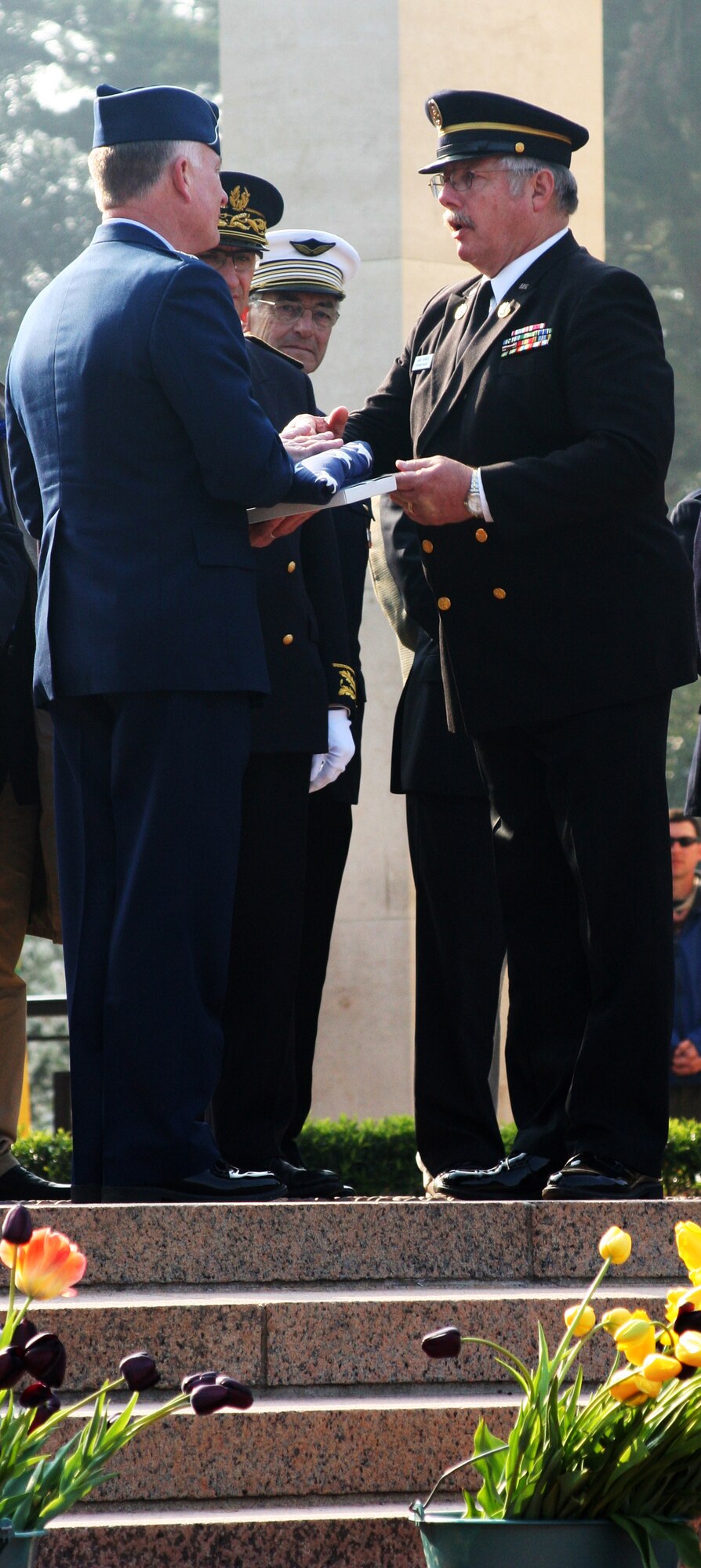 NORMANDY, France -- Maj. Gen. Jack Egginton, U.S. Air Forces in Europe director of operations, a flag that was flown over the American Cemetery at Colleville sur Mer from Hans Hookeras, superintendent of the Normandy American Cemetery, on behalf of the Boy Scouts of America Transatlantic Council as thanks for his tenure serving as the council president of the Boy Scouts of America Transatlantic Council. More than 3,000 Boy Scouts gathered in Normandy for the Boy Scouts of America Transatlantic Council's triennial Normandy Camporee April 15-17, 2011, and concluded the campout with a ceremony honoring those buried at the cemetery overlooking Omaha Beach. (U.S. Air Force photo/Lt. Col. Pamela A.Q. Cook)