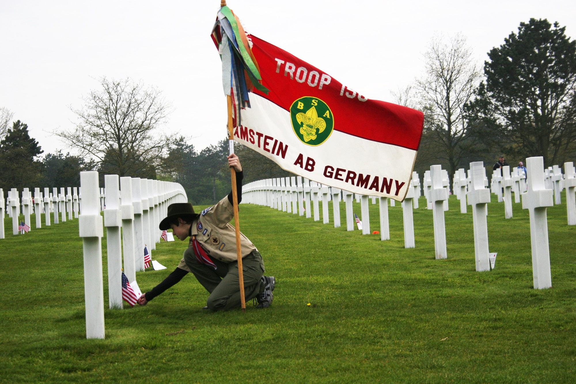 NORMANDY, France -- Quentin Smith, from Boy Scout Troop 156 at Ramstein Air Base, Germany, pauses to read a note left at a gravesite at the American Cemetery at Colleville sur Mer on April 16, 2011. More than 3,000 Boy Scouts gathered in Normandy for the Boy Scouts of America Transatlantic Council's triennial Normandy Camporee. (U.S. Air Force photo/Lt. Col. Pamela A.Q. Cook)
