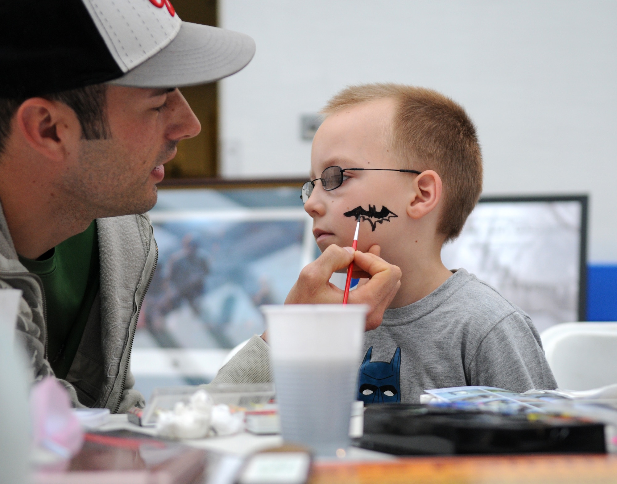 RAF MILDENHALL, England – Senior Airman Kristopher Jarrett, 100th Civil Engineer Squadron power production, colors in a bat on Joshua Dove’s, son of Jacqueline Dove, 100th CES environmental, face during the Earth Week Fair at the Exchange here April 16, 2011. The fair had a face painting booth, quizzes for children, information booths and free educational materials. Earth Week is a week-long celebration of Earth Day between RAFs Mildenhall and Lakenheath. (U.S. Air Force photo/Airman 1st Class Rachel Waller)