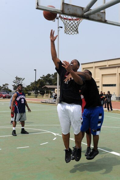KUNSAN AIR BASE, Republic of Korea -- Tech. Sgt. Daniel Johnson, 8th Medical Support Squadron outpatient records NCO-in-charge, goes up for a reverse layup during the 3-on-3 basketball tournament championship game in which the 8th MDSS defeated the 8th Aircraft Maintenance Squadron 15-14 during the 8th Fighter Wing’s post operational readiness inspection block party here April 15. After having received an overall rating of “Excellent” from the Pacific Air Force’s Inspector General, Col. John Dolan, 8th FW commander, authorized a celebration for a job well done. The block party included several events such as bowling and 3-on-3 basketball tournaments, live bands, softball, a dunk tank and more. (U.S. Air Force photo/Tech. Sgt. Jonathan Pomeroy)