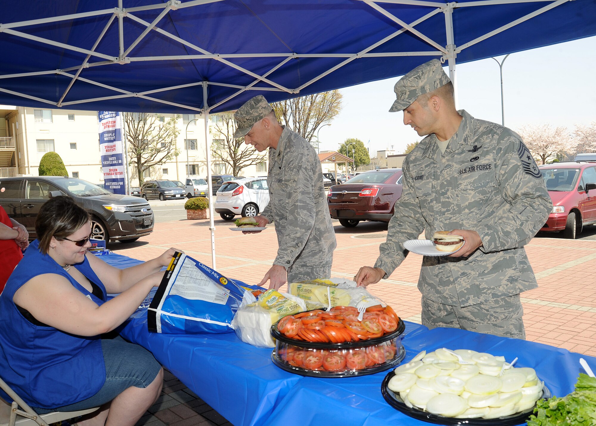 YOKOTA AIR BASE, Japan -- Col. Otto Feather (middle), 374th Airlift Wing commander, and Chief Master Sgt. Ben Caro, 374th AW command chief master sergeant, grab free food outside the Yokota Community Center here April 14, 2011. The free lunch was provided to all Yokota members in appreciation of their time, dedication and hard work since the earthquake and tsunami disaster that struck Japan, March 11. (U.S. Air Force photo/Airman 1st Class Andrea Salazar)