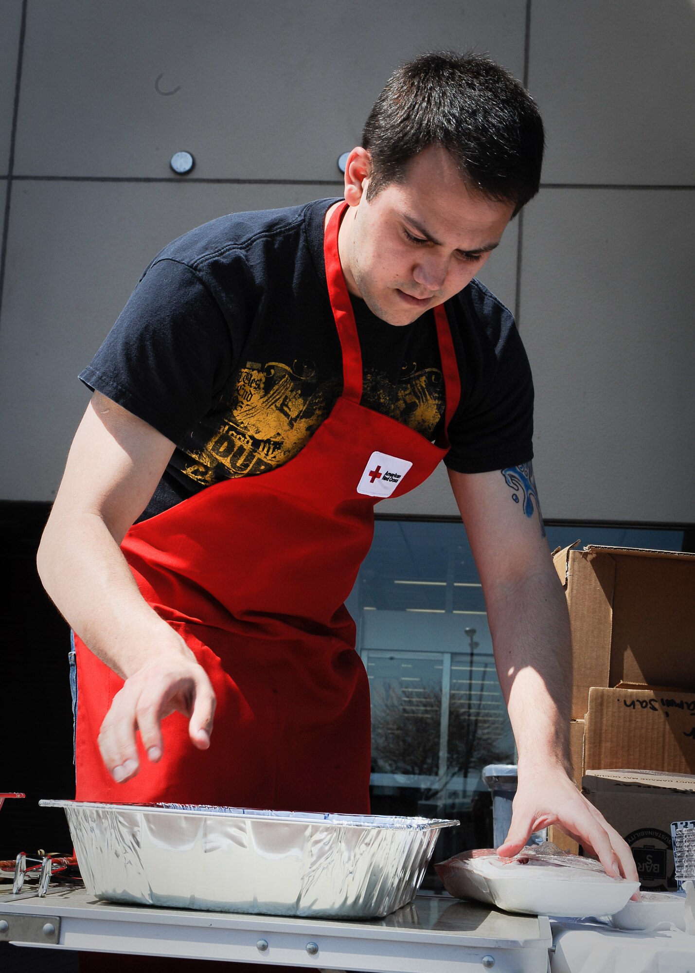 YOKOTA AIR BASE, Japan -- Jeremy Butterworth, American Red Cross volunteer, prepares food outside the Yokota Community Center here April 14, 2011. The Red Cross provided a free lunch to Team Yokota in honor of National Volunteer Appreciation Week and to thank members for their dedication, time and hard work in support of Operation Tomodachi. (U.S. Air Force photo/Airman 1st Class Andrea Salazar)