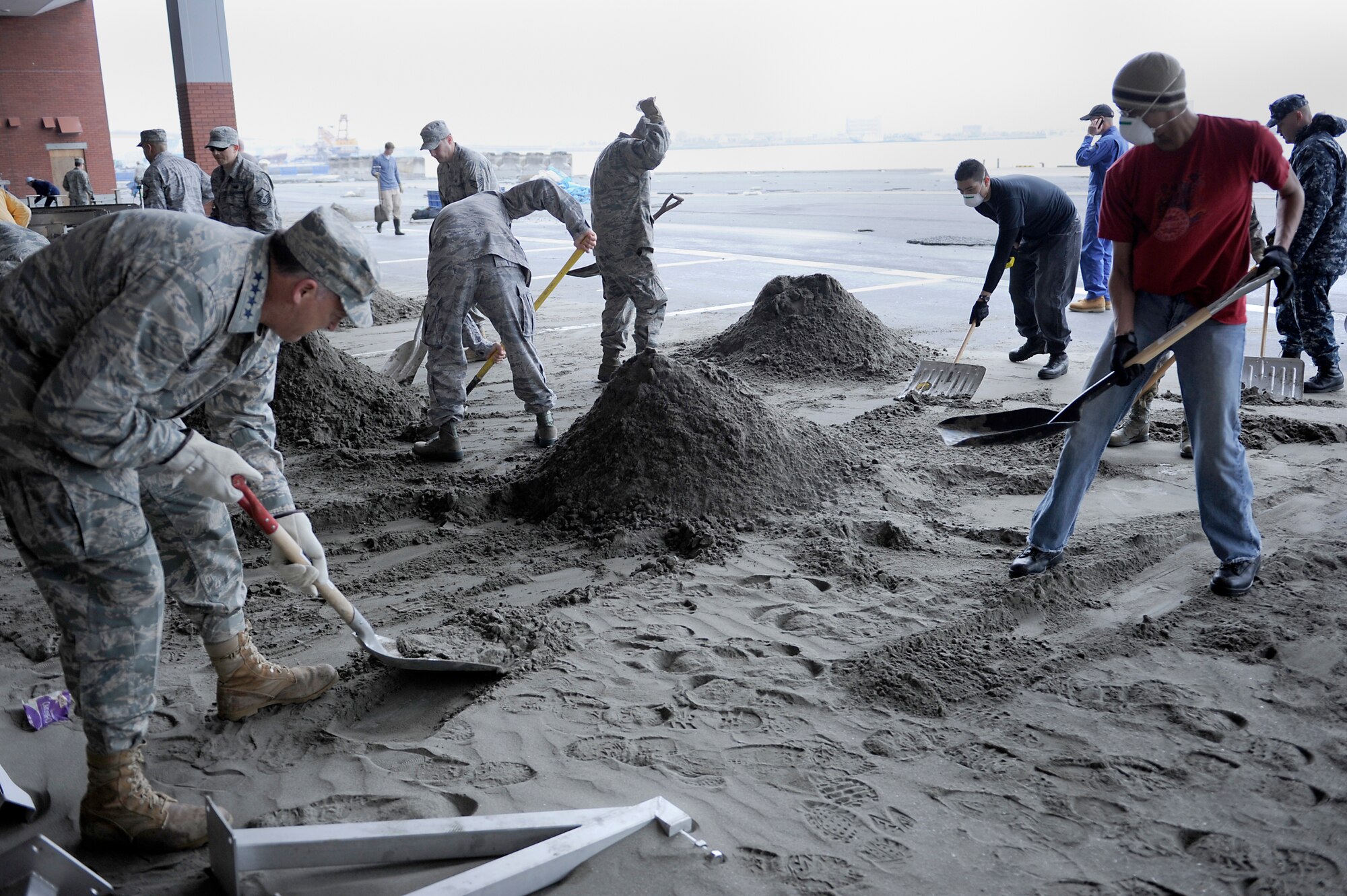 MISAWA AIR BASE, Japan -- Gen. Gary North, Pacific Air Forces commander, left, alongside Airmen, Sailors and civilian volunteers from Misawa clean up the Hachinohe Port April 16. General North was the 2,000th volunteer to sign up through the Misawa Helps program. (U.S. Air Force photo by Staff Sgt. Marie Brown\Released)