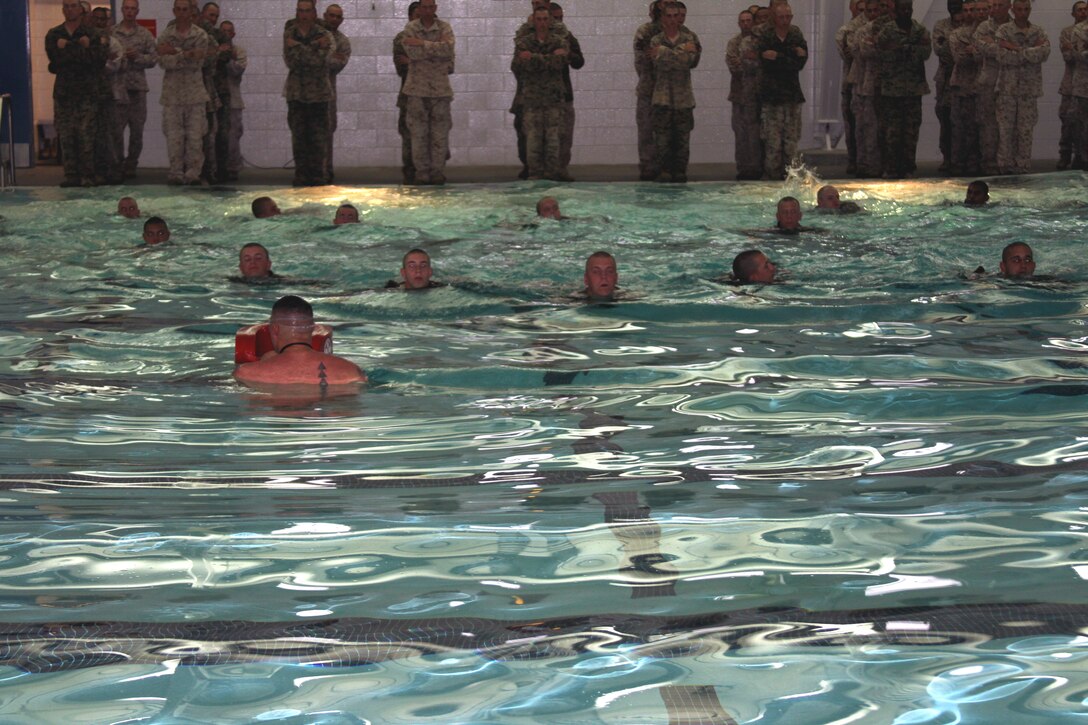 A Marine Corps Instructor of Water Survival teaches the recruits of Company E how to tread water for five minutes as part of the Marine Corps Water Survival Training Program at the depot pool April 18.
