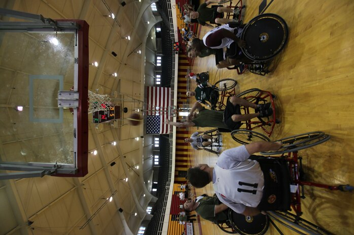 A wounded warrior with the Warrior Athlete Reconditioning Program, Wounded Warrior Battalion – East, goes for the net during their first wheelchair basketball game at the Geottge Memorial Field House aboard Marine Corps Base Camp Lejeune, April 19. The wounded warriors faced off against staff members of the WWBn-East and won with a score of 34-14.