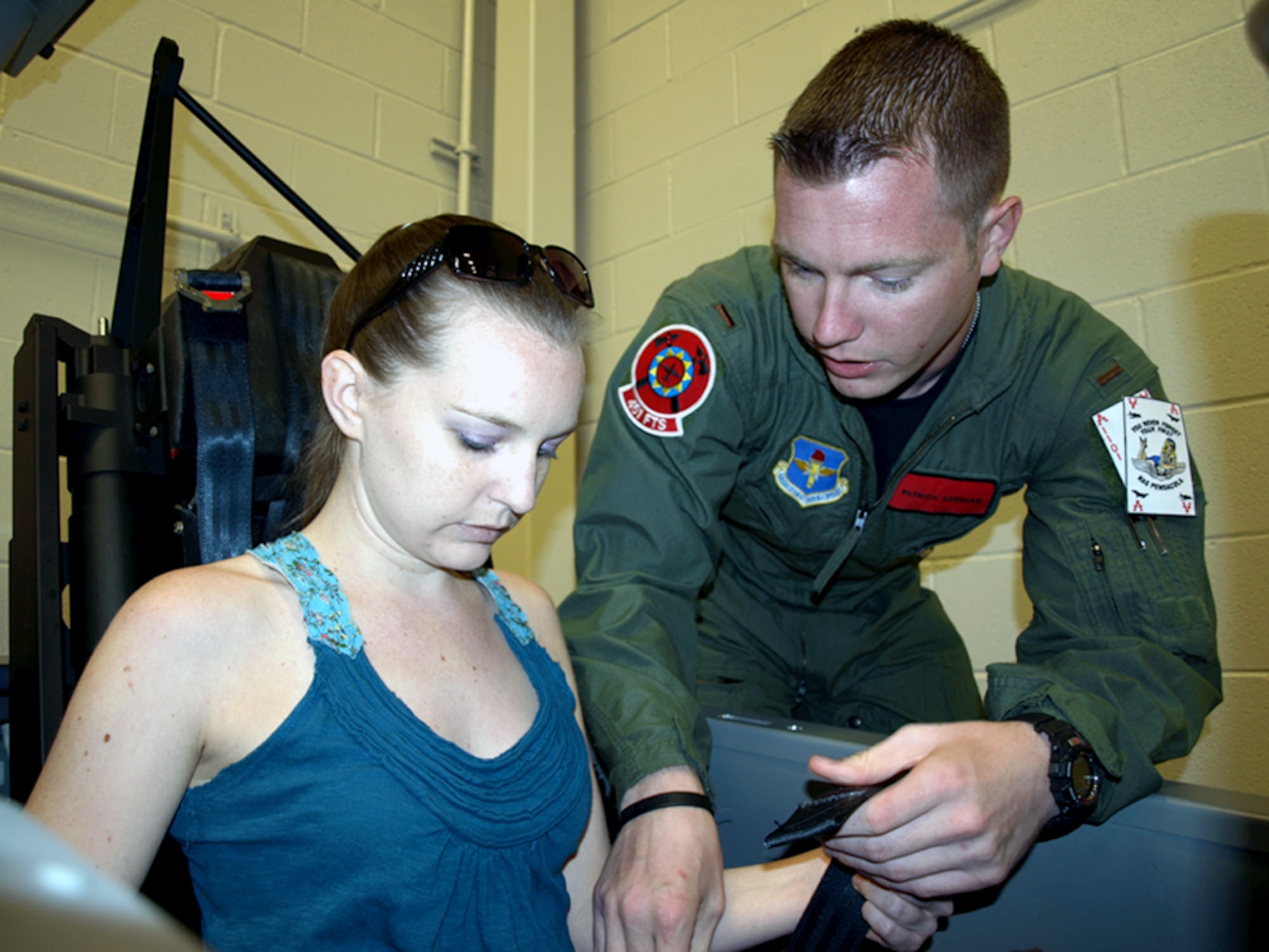 Second Lt. Patrick Sheehan shows a T-6 Texan II cockpit mock-up to his sister, Kate, April 14, 2011, at Naval Air Station Pensacola, Fla. The mock-up is used by combat systems officer trainees to practice getting into and out of the T-6, as well as canopy operation procedures. Lieutenant Sheehan is a CSO trainee participating in the CSO training program sponsored by members of the 479th Flying Training Group there. (U.S. Air Force photo)