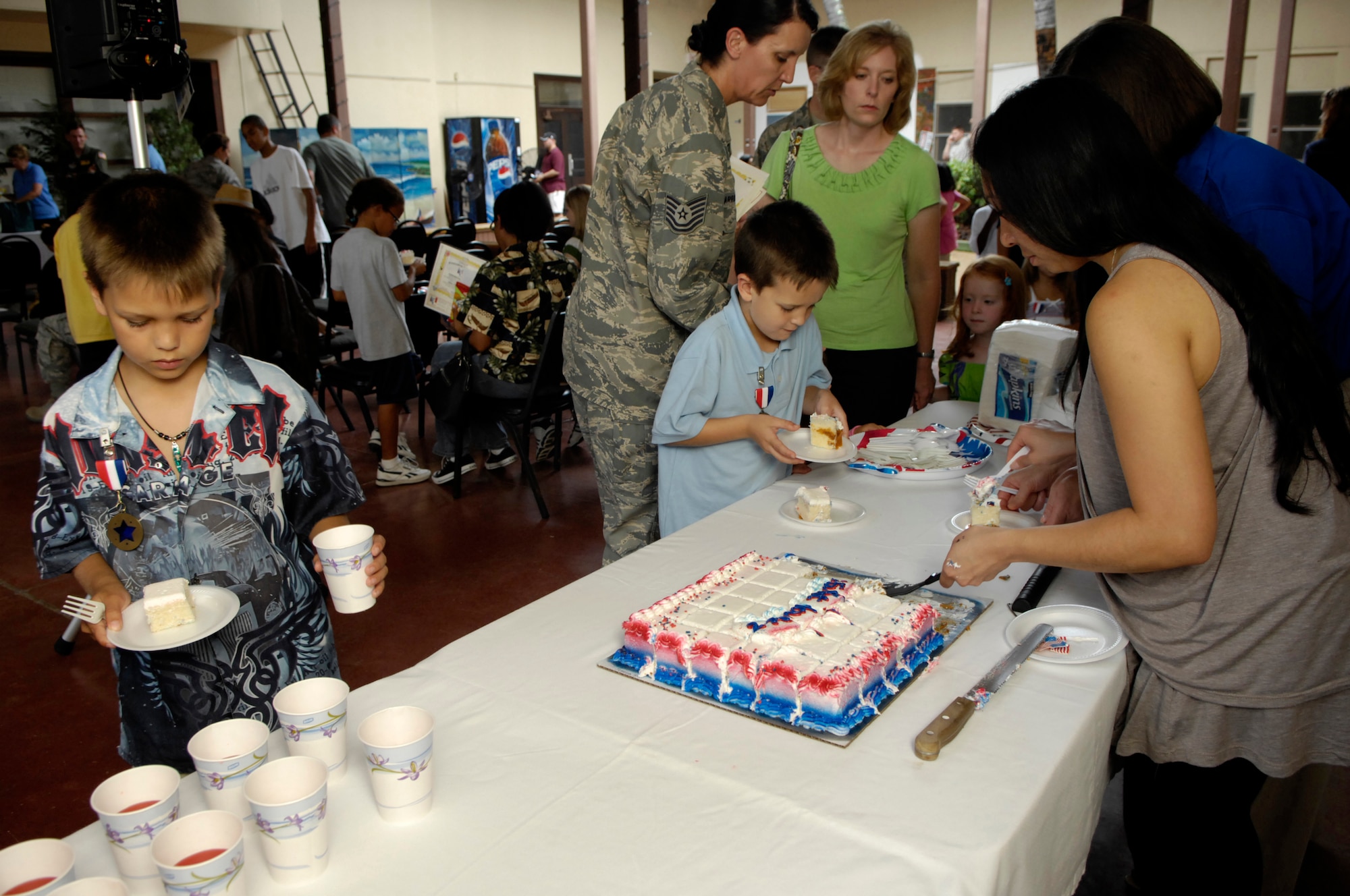 Dylan (left) and Conner Palumbo enjoy some cake after receiving medals as Homefront Heroes, recognizing them for their contributions and sacrifices during their sponsor's military deployment.  Photo by David D. Underwood, Jr.
