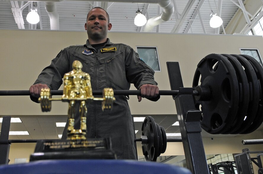 Capt. Dustin Long, 11th Bomb Squadron, stands behind his trophy on a weight bench in the fitness center on Barksdale Air Force Base, La., April 19. Captain Long was the top male performer in the Maxed Out Friday Bench Press Competition. Contestants were given three attempts to reach their maximum lifting weight. (U.S. Air Force photo/Airman 1st Class Micaiah Anthony)(RELEASED)