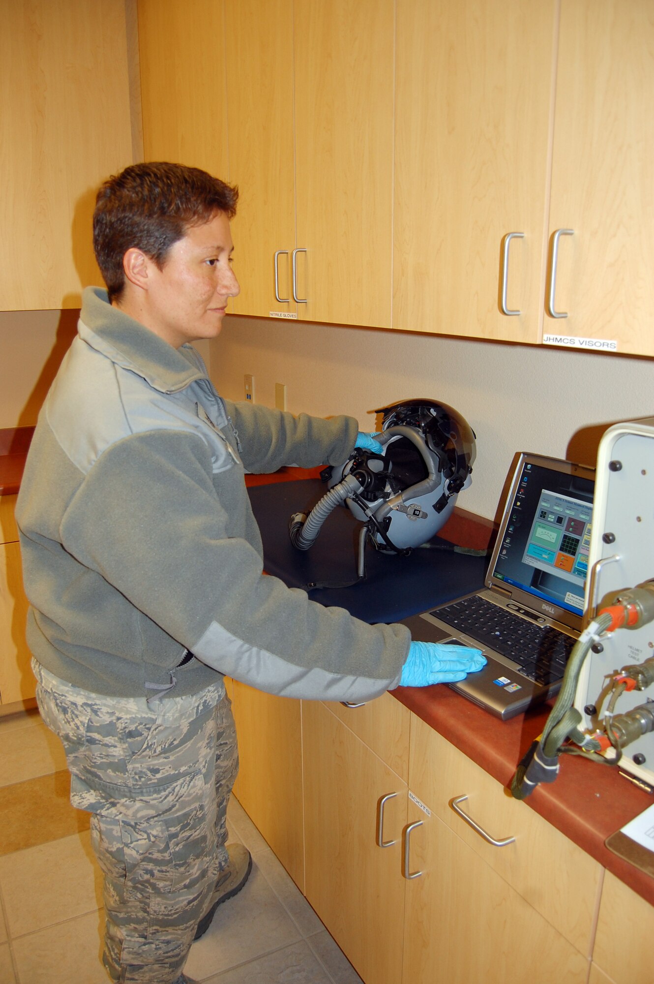 NELLIS AIR FORCE BASE, Nev. -- Tech. Sgt. Heather Devine, 926th Group, conducts a pre-flight helmet inspection using the Joint Helmet Mounted Cueing Station here April 6.  Sergeant Devine is a reservist integrated into the active duty's 57th Adversary Tactics Support Squadron here, maintaining aircrew flight equipment for F-15 and F-16 Aggressor pilots. (U.S. Air Force photo/Capt. Jessica Martin)