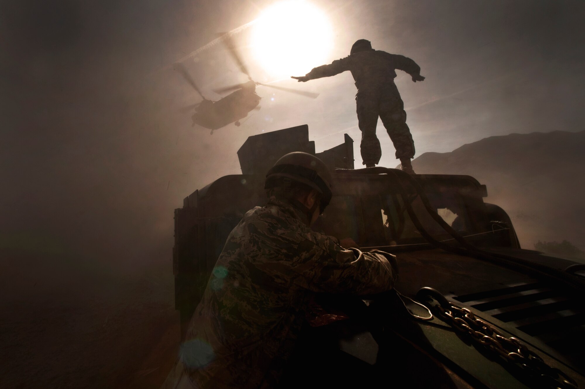 NELLIS AIR FORCE BASE, Nev. -- U.S. Army Staff Sgt. Hector Hoyas, a Aerial Delivery Field Service Department instructor from Fort Lee, Va., waves off a Nevada Army National Guard 1/189 Aviation Company CH-47 Chinook helicopter as Airmen from the 820th RED HORSE Squadron's airborne flight, secure the mirrors before hooking the HUMVEE up to the Chinook for sling-load April 15. The Nevada Army National Guard, ADFSD, and the 820th airborne flight conducted airdrops and sling-load training.  (U.S. Air Force photo by Tech. Sgt. Michael R. Holzworth)

