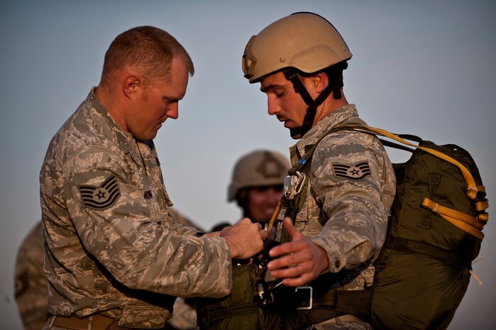 NELLIS AIR FORCE BASE, Nev. --Tech. Sgt. Mitchell Romag, performs  a Jumpmaster Pre-inspection of Air Force Staff Sgt. Jeremy Lowe's parachute before a training jump April 15. Sergeant Romag is an airborne pavements and equipment operator and Sergeant Lowe is an airborne vehicle maintenance craftsman, assigned to the 820th RED HORSE Squadron's airborne flight. Airborne RED HORSE are different than the rest of traditional RED HORSE in that members are airborne qualified and use much lighter specialized equipment. (U.S. Air Force photo by Tech. Sgt. Michael R. Holzworth)