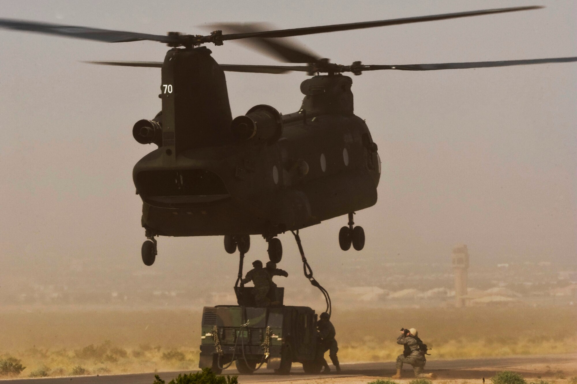 NELLIS AIR FORCE BASE, Nev. --Tech. Sgt. Michael Holzworth, 99th Air Base Wing photojournalist, documents a Nevada Army National Guard CH-47 Chinook helicopter, 1/189th Aviation Company, and U.S. Air Force Airmen from the 820th RED HORSE Squadron's airborne flight April 15. Airborne RED HORSE are different than the rest of traditional RED HORSE  in that members are airborne qualified and use much lighter specialized equipment.(U.S. Air Force photo by Senior Airman Brett Clashman/Released)