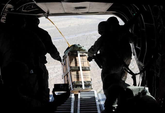NELLIS AIR FORCE BASE, Nev. --Cargo is pushed out from a CH-47 Chinook helicopter from the Nevada National Guard, 1/189th Aviation Company during air drop and sling-load training with the 820th RED HORSE squadron's airborne flight on April 15, 2011 over Nellis. Air drop and sling-load operations are a vital part of war zone logistics. In a changing battlefield the more options to resupply a location the better. Sling- load operations also allow for a quick rig and drop, a testimony to both the pilots flying the aircraft and the Soldiers on the ground. (U.S. Air Force photo by Master Sgt. Kevin J. Gruenwald)