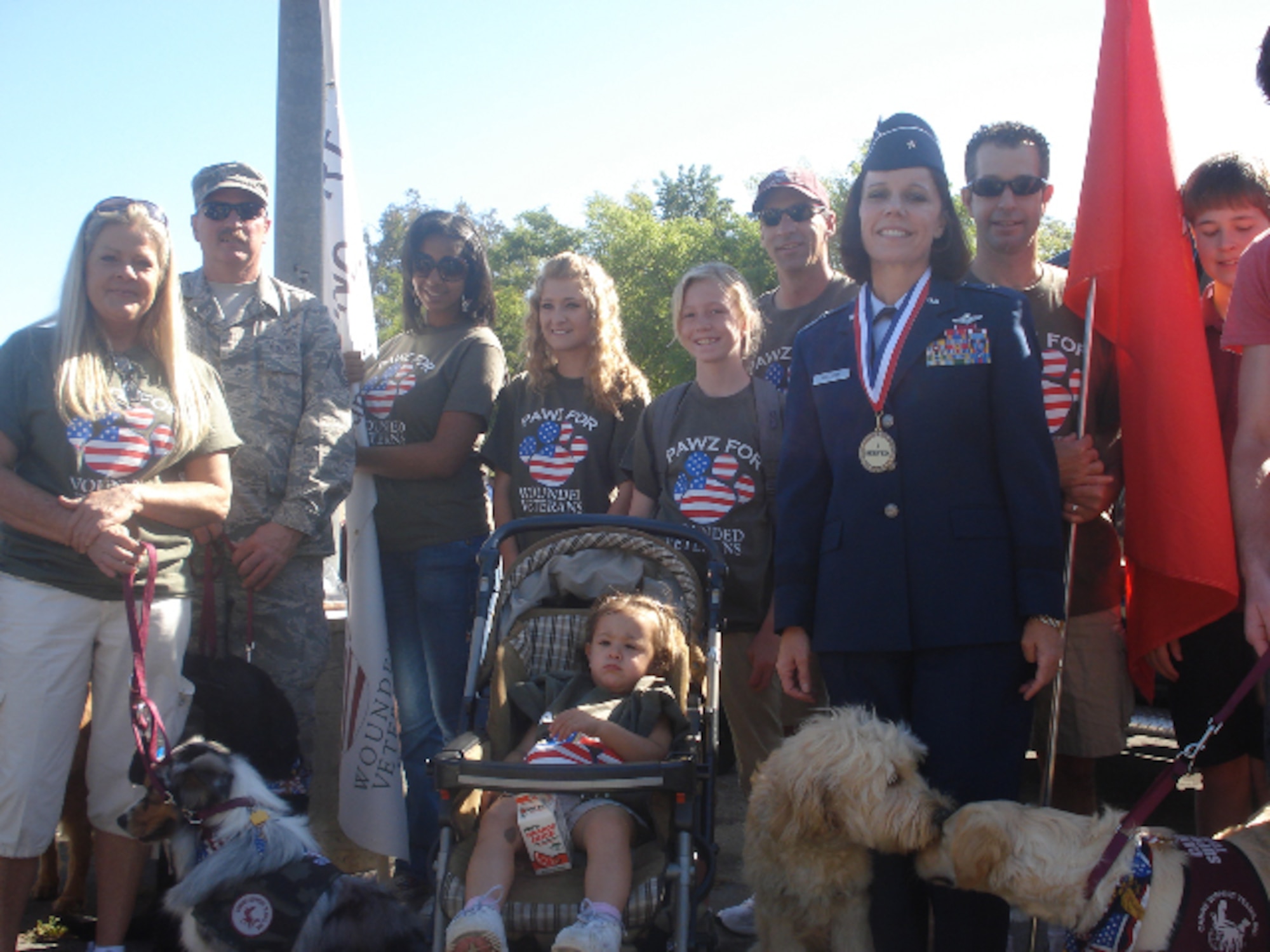 Brig. Gen. Pamela Milligan, Vice-Commander, 4th Air Force, Air Force Reserve Command, March Air Reserve Base, Calif., poses with members of "Pawz for Wounded Veterans," at the 6th annual "Salute to Veterans Parade" in downtown Riverside, Calif., April 16, 2011.  "Paws for Wounded Veterans" is an organization that provides service dogs free of charge to those who have been wounded during military service and require the help of an assistance dog.  General Milligan was a member of the reviewing party during the 132-unit parade, which was themed "Honoring Those Who Have Sacrificed" and featured participants from military units from across southern California. 
