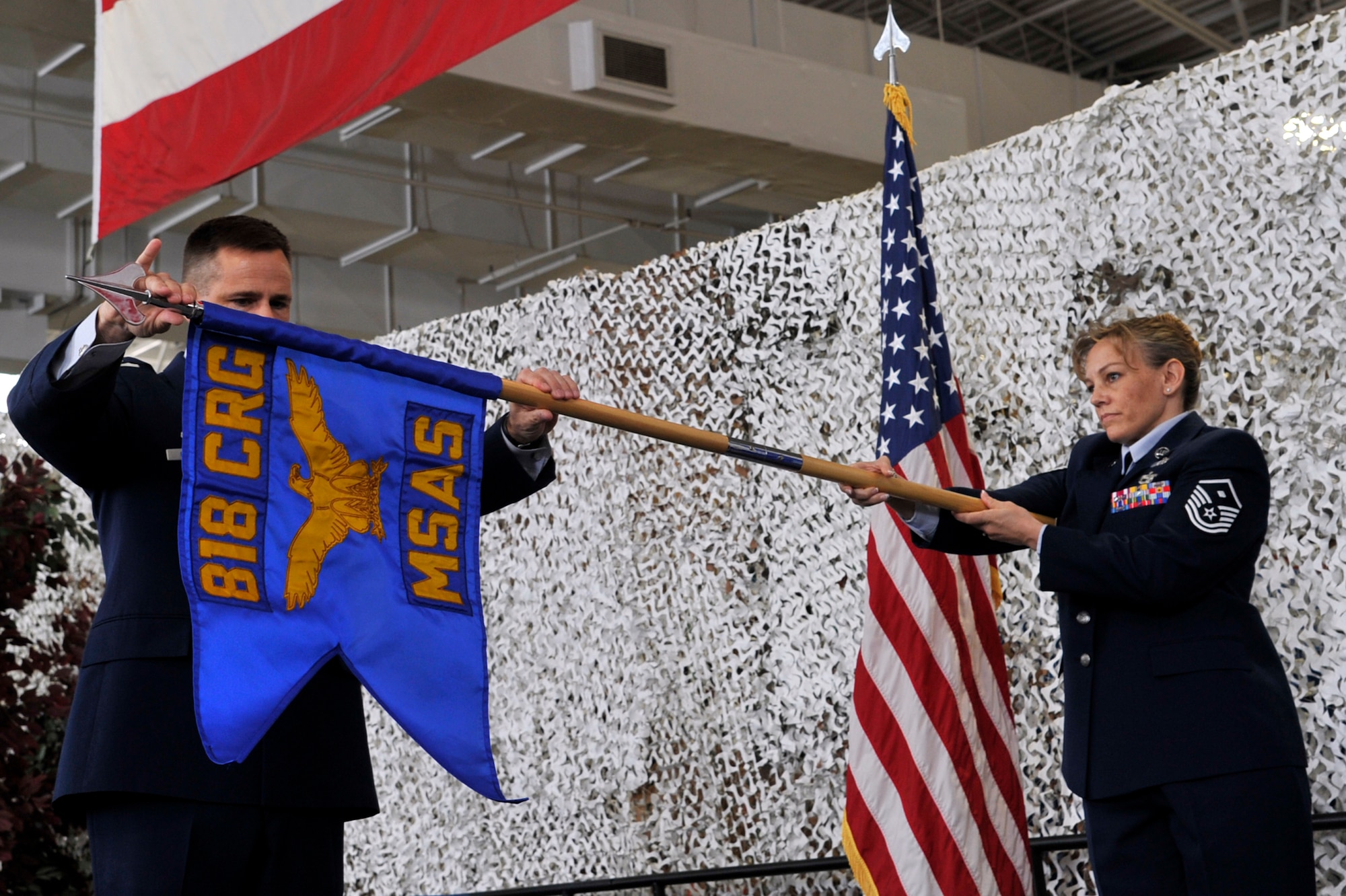 Col. Dean Bridger, 818th Contingency Response Group commander and Master Sgt. Karen Muncey, 818th CRG first sergeant, unfurl the guidon of the 818th Mobility Support Advisory Squadron during its  activation ceremony at Joint Base McGuire-Dix-Lakehurst’s Global Reach Deployment Center April 19. The 818th MSAS will provide air mobility advisory and training support to partner nations in Africa. (U.S. Air Force photo by Tech. Sgt. Laura Deckman) 