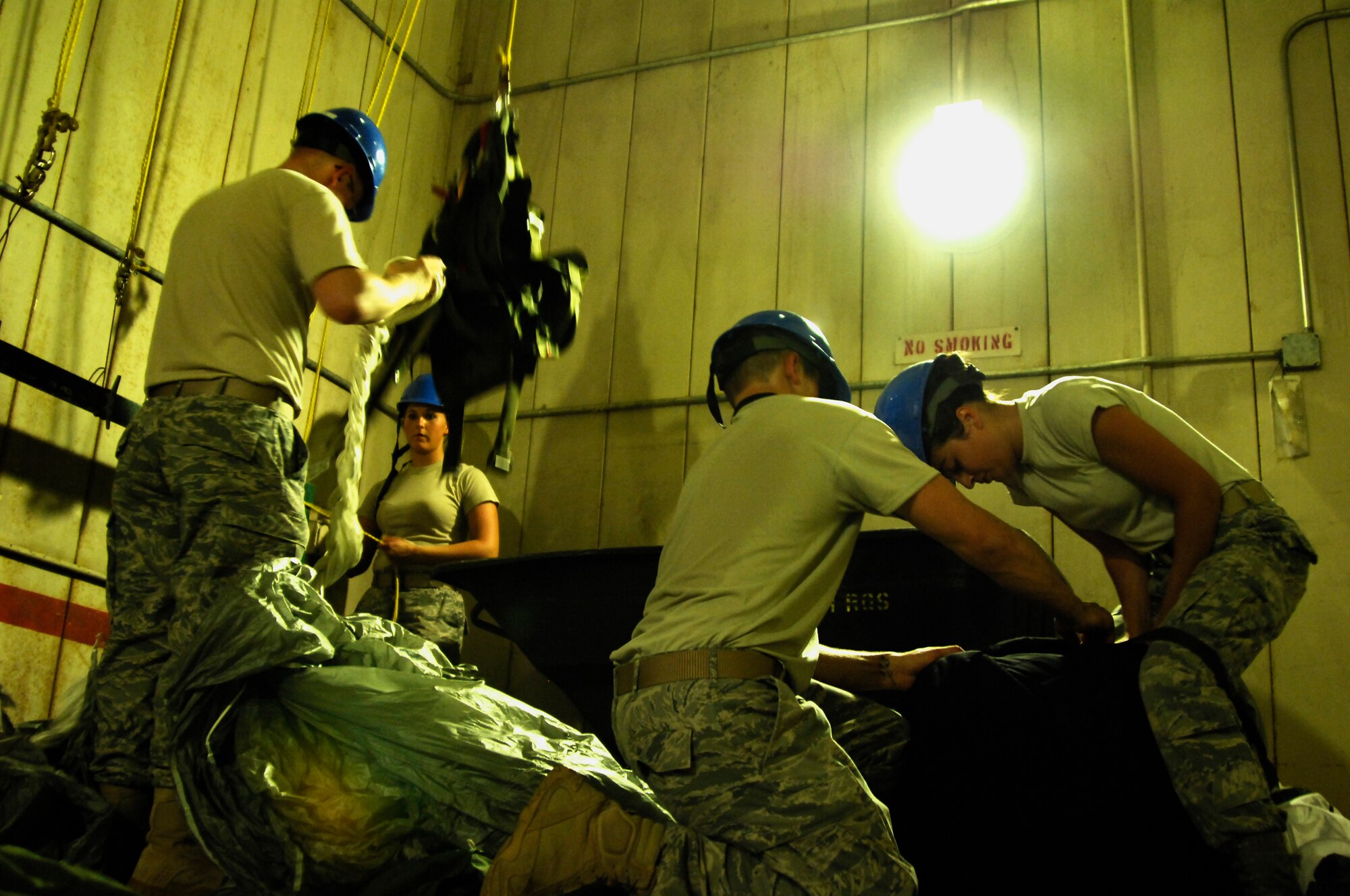 A team from the 38th Rescue Squadron aircrew flight equipment section work together April 12 at Moody Air Force Base, Ga., to take down all the parachutes that were hung four days earlier after a water training mission for the squadron’s pararescuemen. The chutes are rinsed and dried after being immersed in salt water so that the material isn’t weakened. (U.S. Air Force photo/Airman 1st Class Brigitte N. Brantley-Sisk)(RELEASED)
