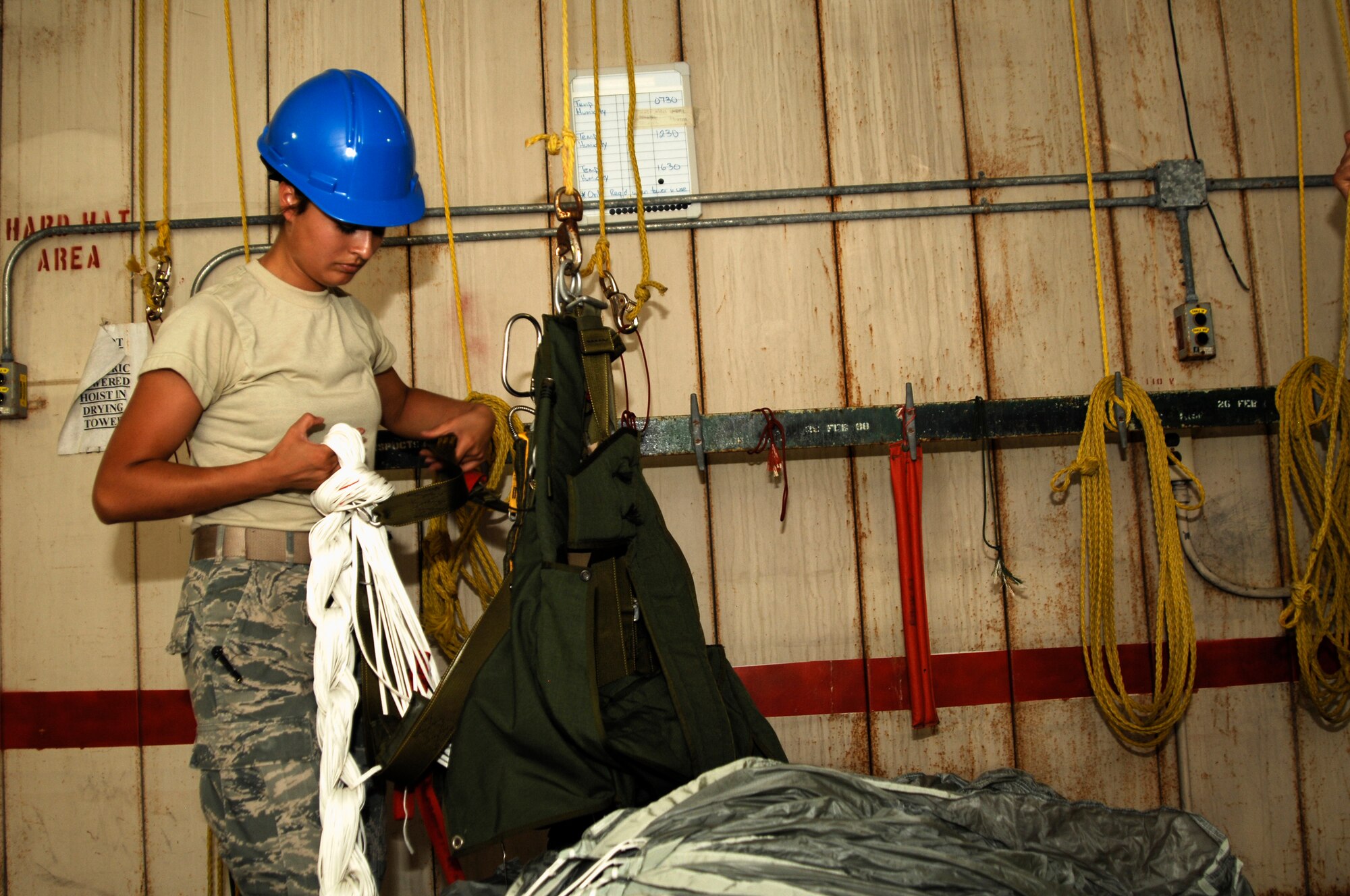Senior Airman Andrea Brandenburg, 38th Rescue Squadron aircrew flight equipment journeyman, secures a daisy chain on parachute April 12 at Moody Air Force Base, Ga., after hoisting it down from a drying tower. This ensures the daisy chain won’t come undone while being transported back to the shop to be packed again. (U.S. Air Force photo/Airman 1st Class Brigitte N. Brantley-Sisk)(RELEASED)

