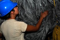 Senior Airman Andrea Brandenburg, 38th Rescue Squadron aircrew flight equipment journeyman, takes down an MC-5 parachute April 12 at Moody Air Force Base, Ga., after it hung for four days in a drying tower. The chutes must be hung within 24 hours of completing training in salt water so the structural integrity isn’t compromised. (U.S. Air Force photo/Airman 1st Class Brigitte N. Brantley-Sisk)(RELEASED)

