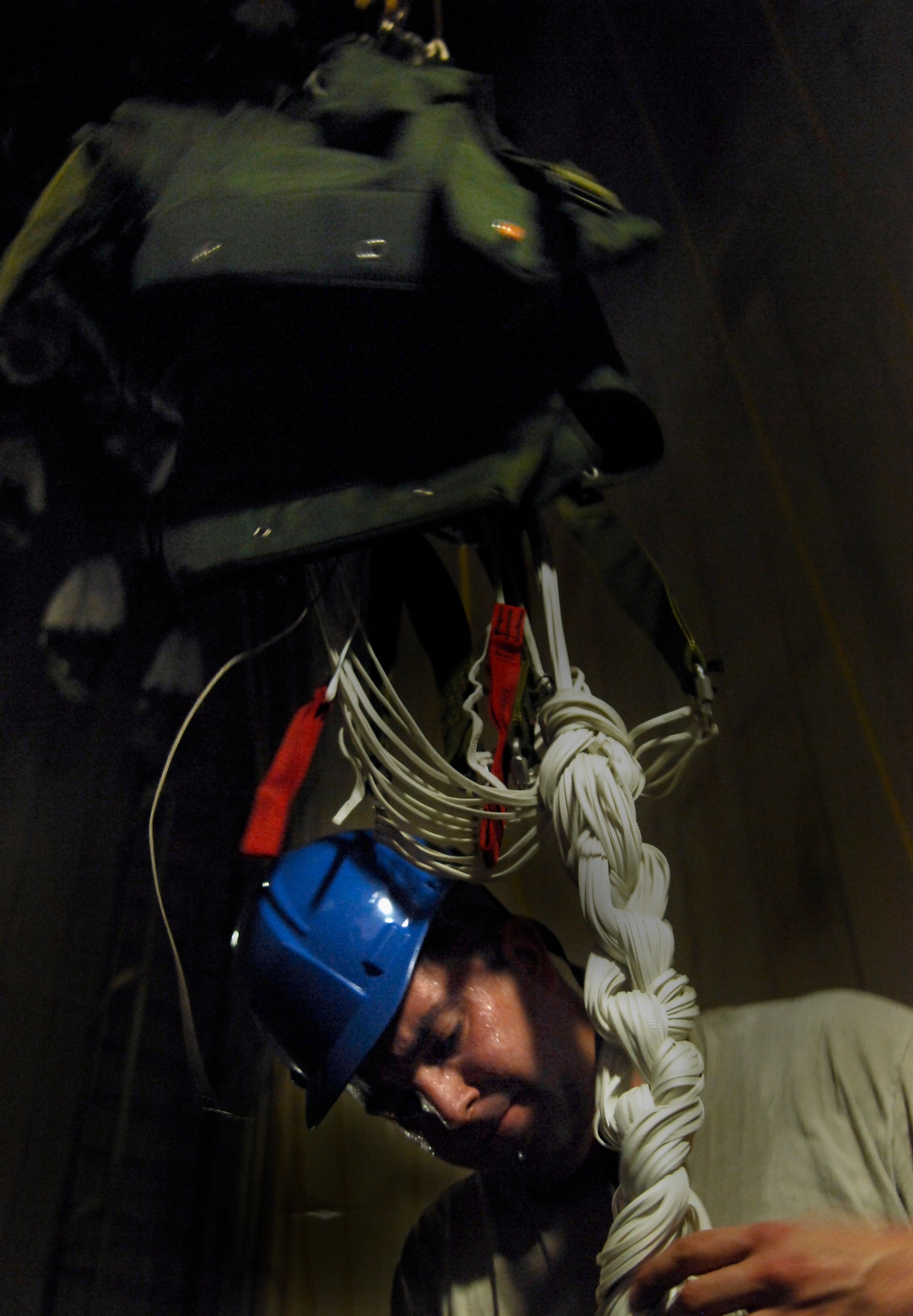 Staff Sgt. Clint Scott, 38th Rescue Squadron aircrew flight equipment NCO, undoes the daisy chain of an MC-5 parachute April 8 in a drying tower Moody Air Force Base, Ga. This parachute was one of about 50 used to support 38th RQS pararescuemen during recent water training. (U.S. Air Force photo/Airman 1st Class Brigitte N. Brantley-Sisk)(RELEASED)
