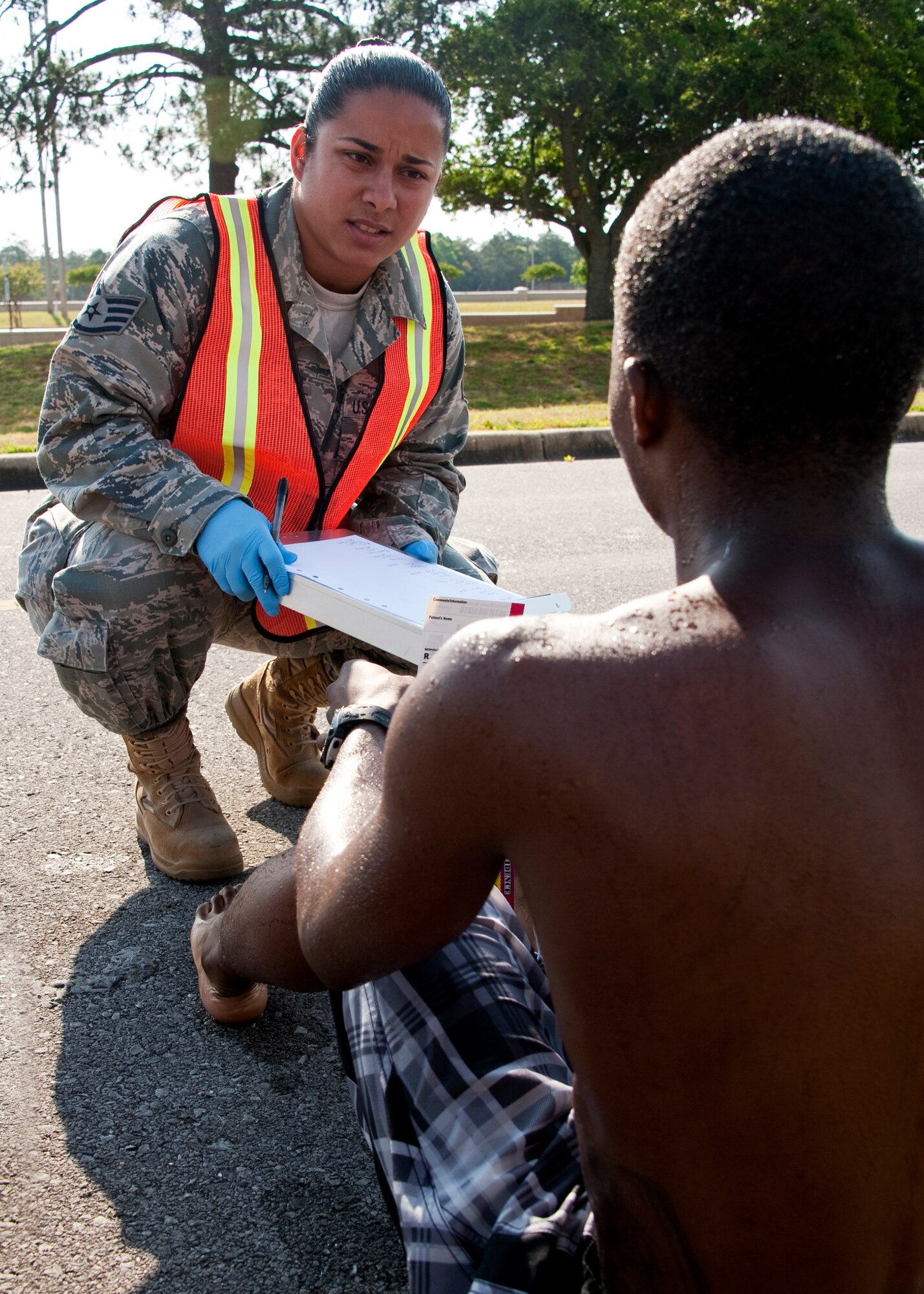 Staff Sgt. Vimari Tynes, 96th Medical Group, questions the quarantined victims during a simulated chemical agent/suspicious package exercise April 19 at Eglin Air Force Base, Fla.  Firefighters, security forces and emergency personnel responded to the incident and the building was evacuated and cordoned during the exercise.    (U.S. Air Force photo/Samuel King Jr.)