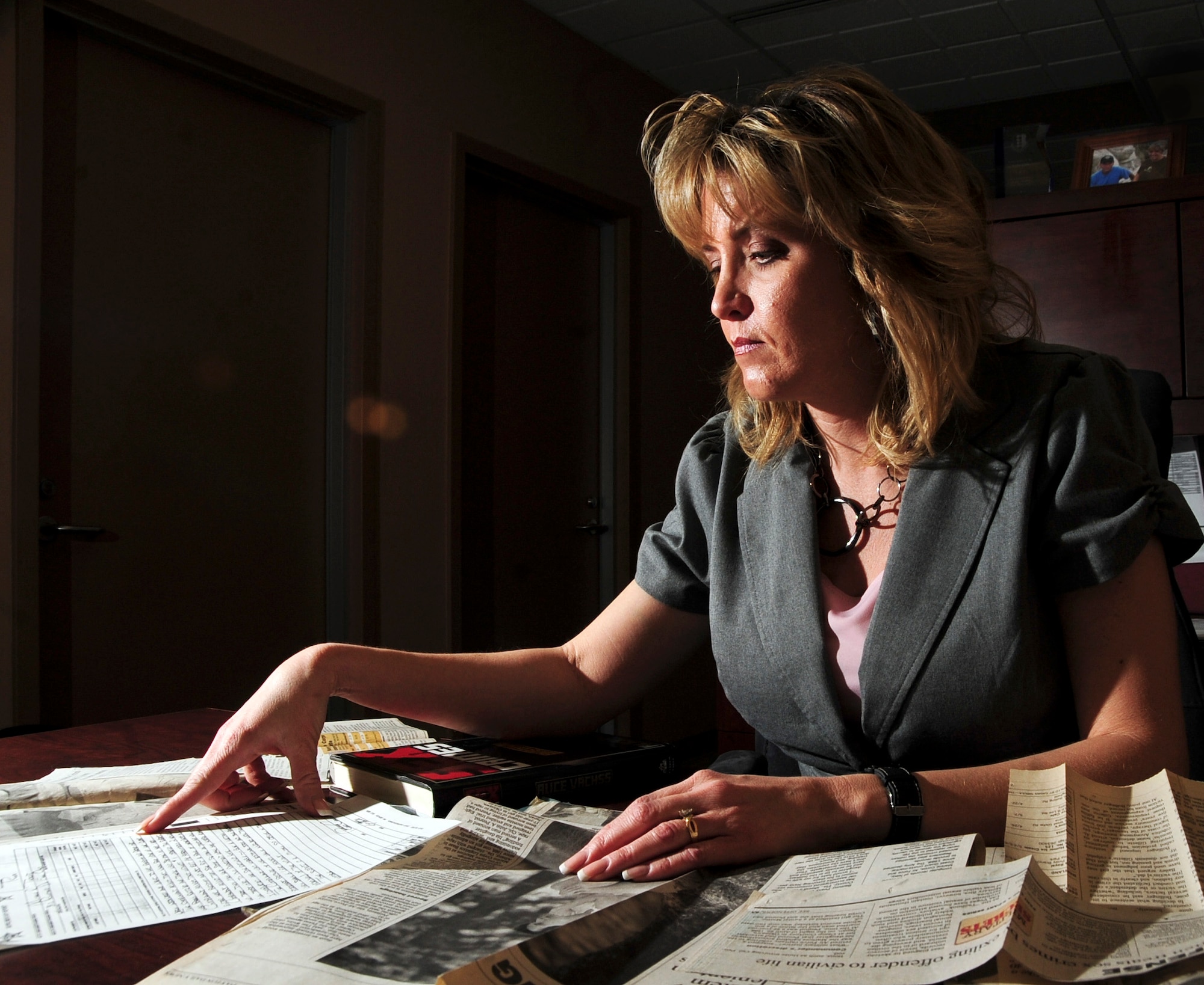 Michele Rogers, a 28th Bomb Wing protocol specialist at Ellsworth Air Force Base, S.D., looks at newspaper clippings and court notes related to her 1993 sexual assault April 5, 2011. The crime, which took place at a house party, led to the removal of a senior airman from the Air Force. (U.S. Air Force photo/Senior Airman Adam Grant)