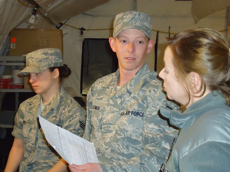 Senior Airman Christina N. Muniz and Staff Sgt. Christopher M. Jones, both from the 103rd Force Support Squadron, 103rd Airlift Wing, Conn. Air National Gurad, give a status report for appropriated fund/nonappropriated fund operations to Lt. Col. Ann C. Ware, 103rd Force Support Squadron commander, during a combat training exercise March 24, 2011, at Dobbins Air Reserve Base, Ga. A team of 15 Connecticut Guardsmen deployed with members of the 104th FSS and MacDill AFB where they focused on wartime/contingency operations relative to a force beddown.  (Photo courtesy of Master Sgt. Melissa A. Letizio)