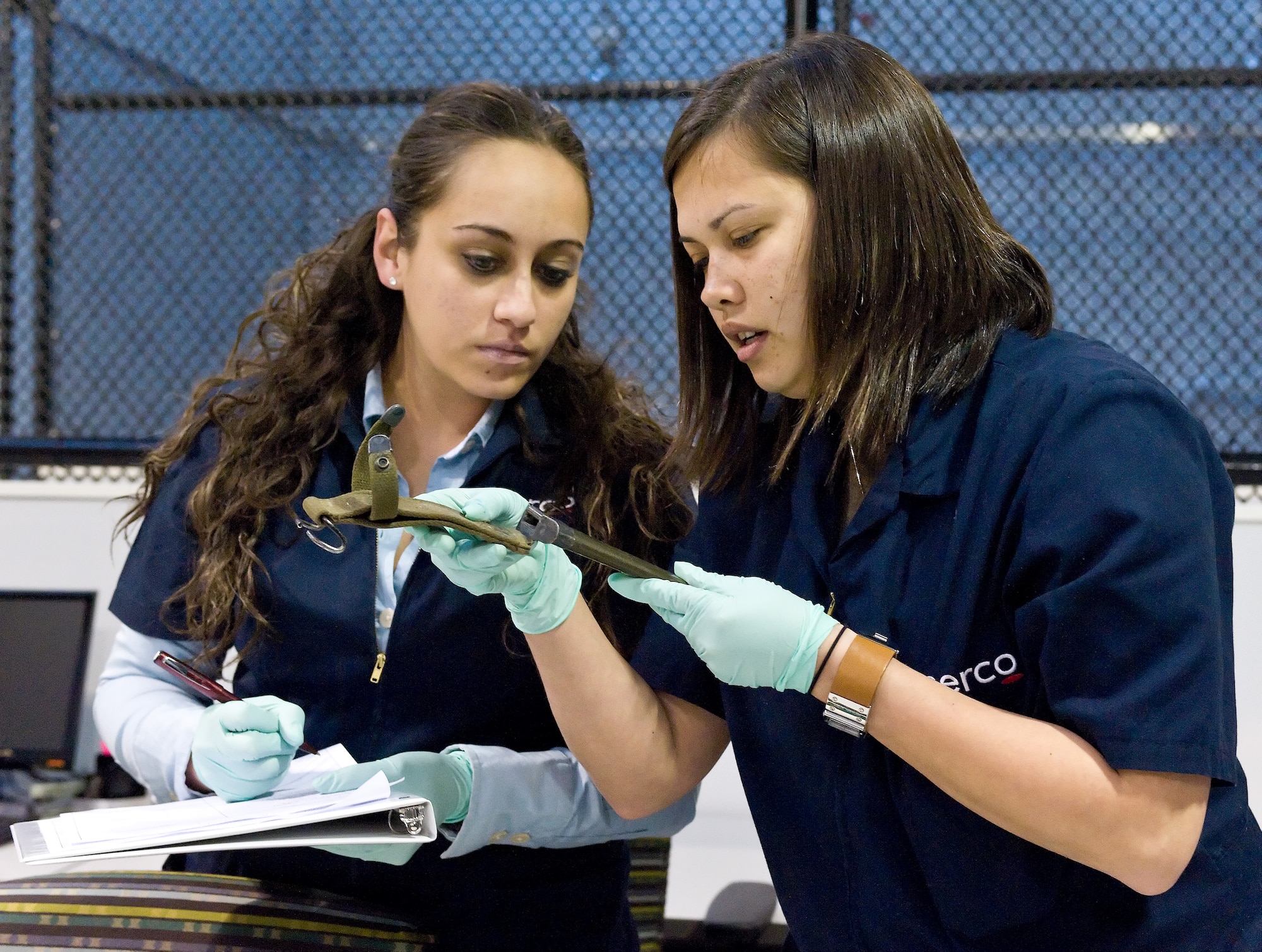 Virginia Garcia, left, and Dawn Senidoleitch demonstrate how to catalogue and document personal effects April 14, 2011, at the new Joint Personal Effects Depot at Dover Air Force Base, Del. (U.S. Air Force photo by Roland Balik)
